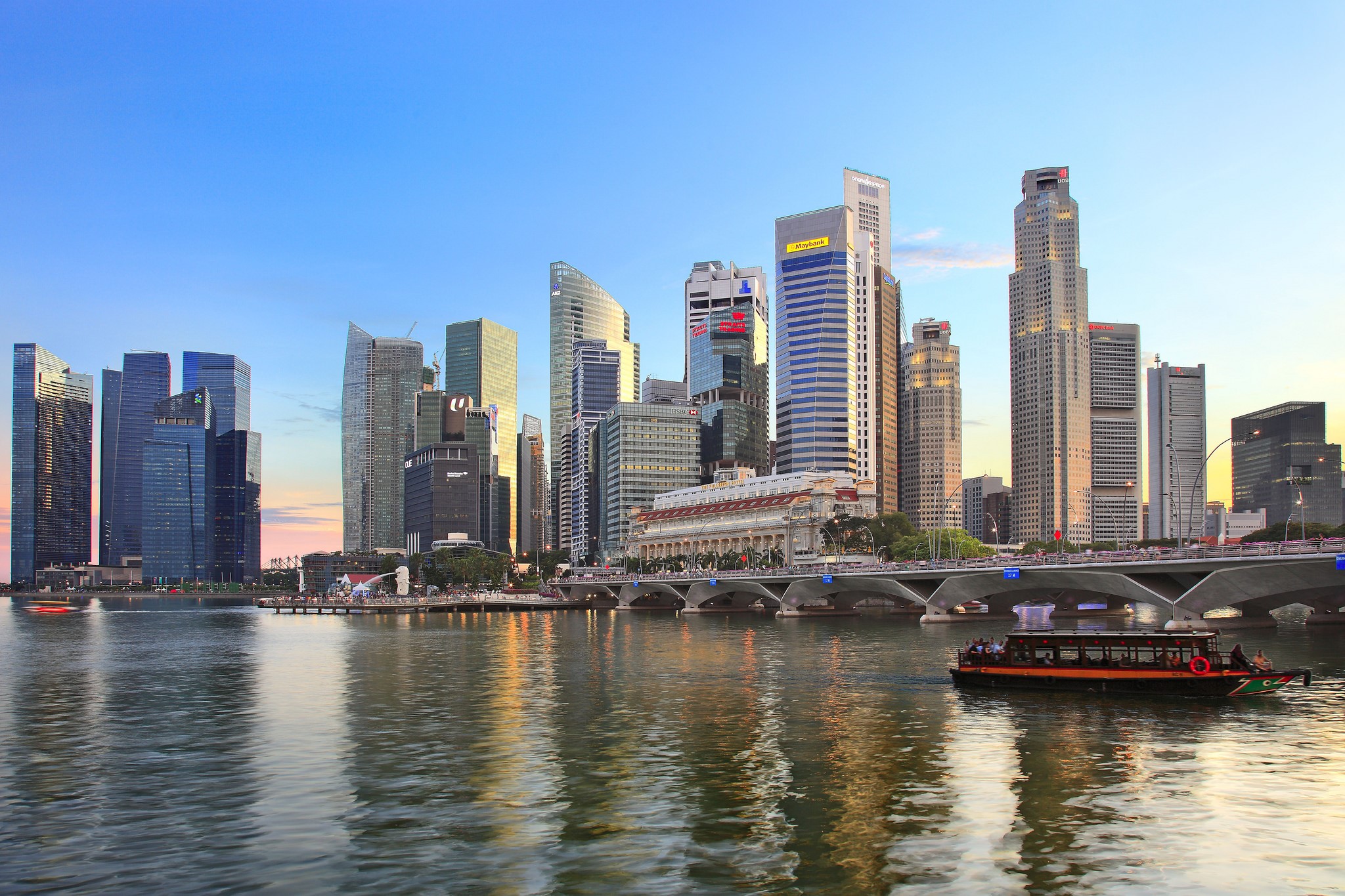Singapore skyline with skyscrapers and a boat on the water HD Wallpaper