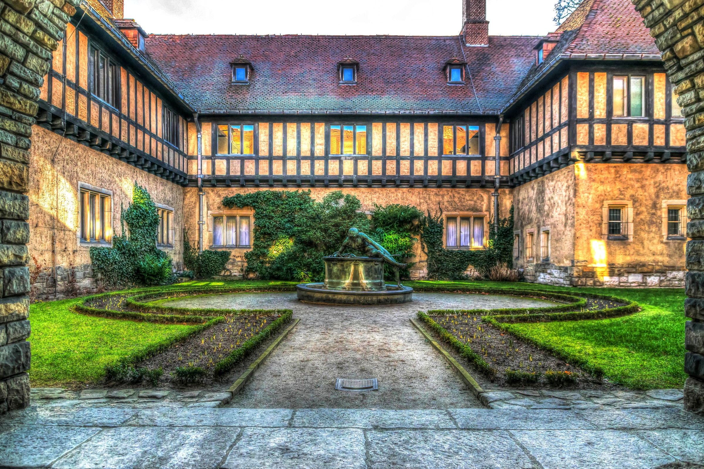 Cecilienhof Castle courtyard with fountain and garden in Potsdam, Germany HD Wallpaper