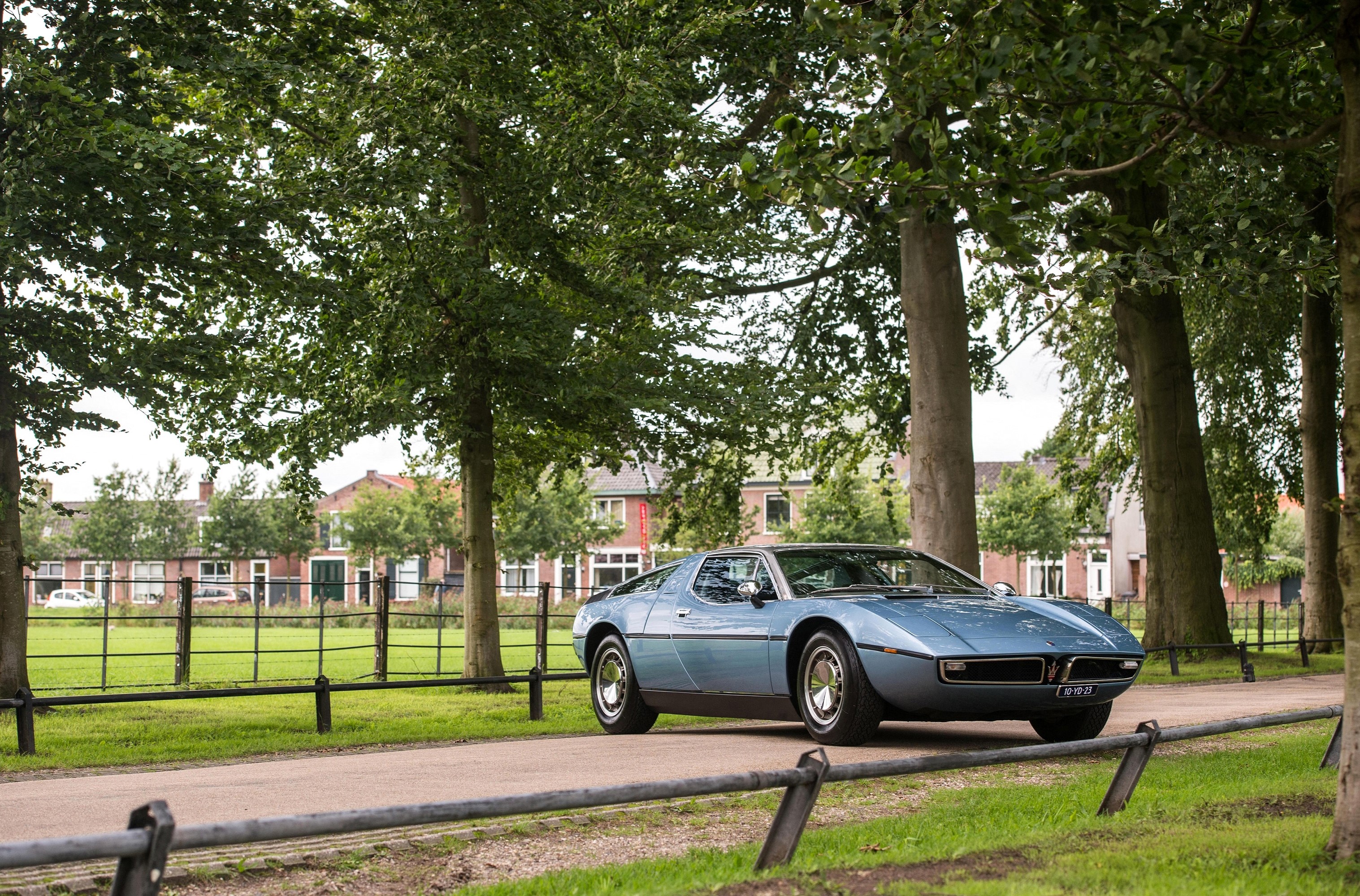 Blue Maserati Bora AM117 parked on a tree-lined road HD Wallpaper