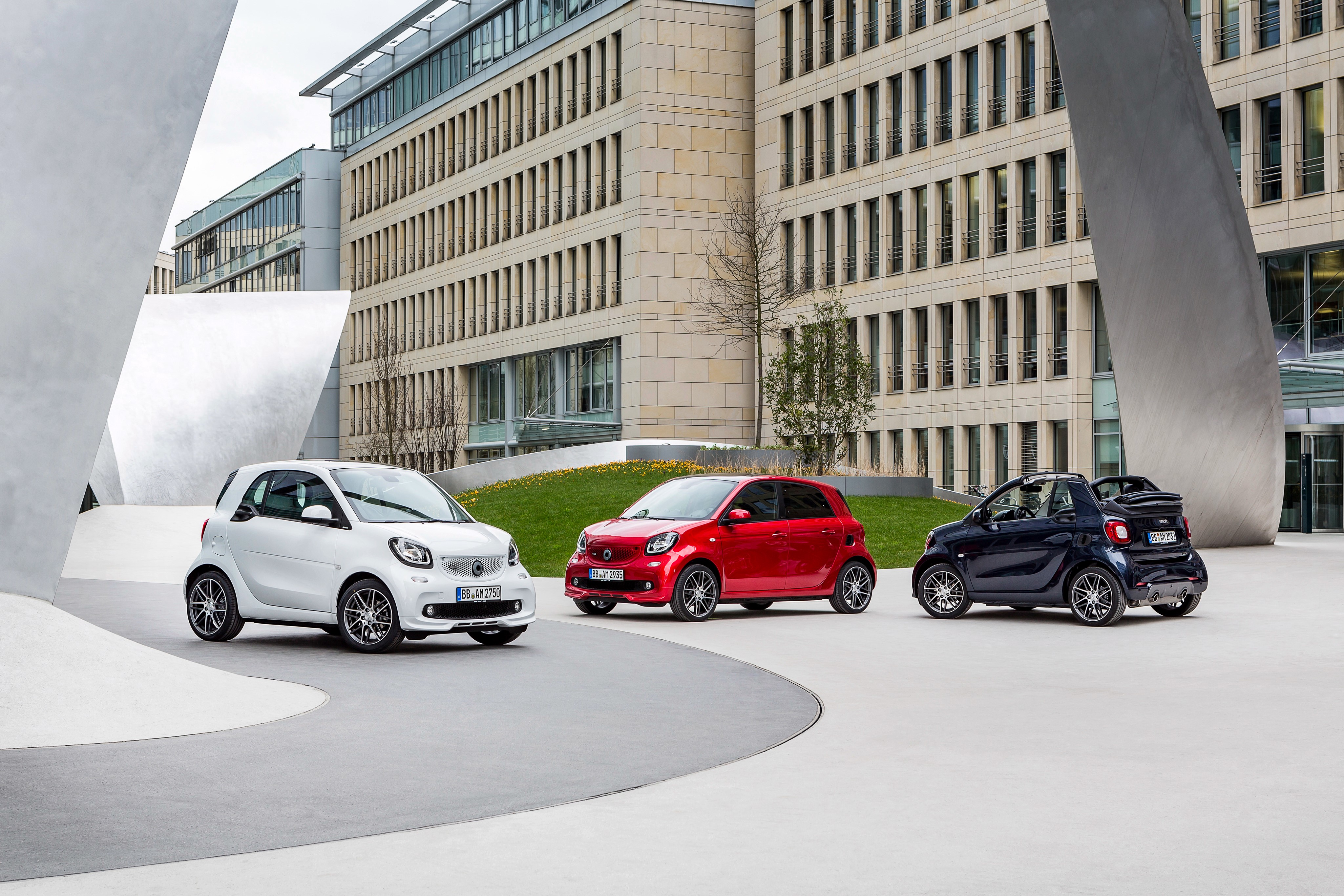 Smart Cars in front of a modern building HD Wallpaper