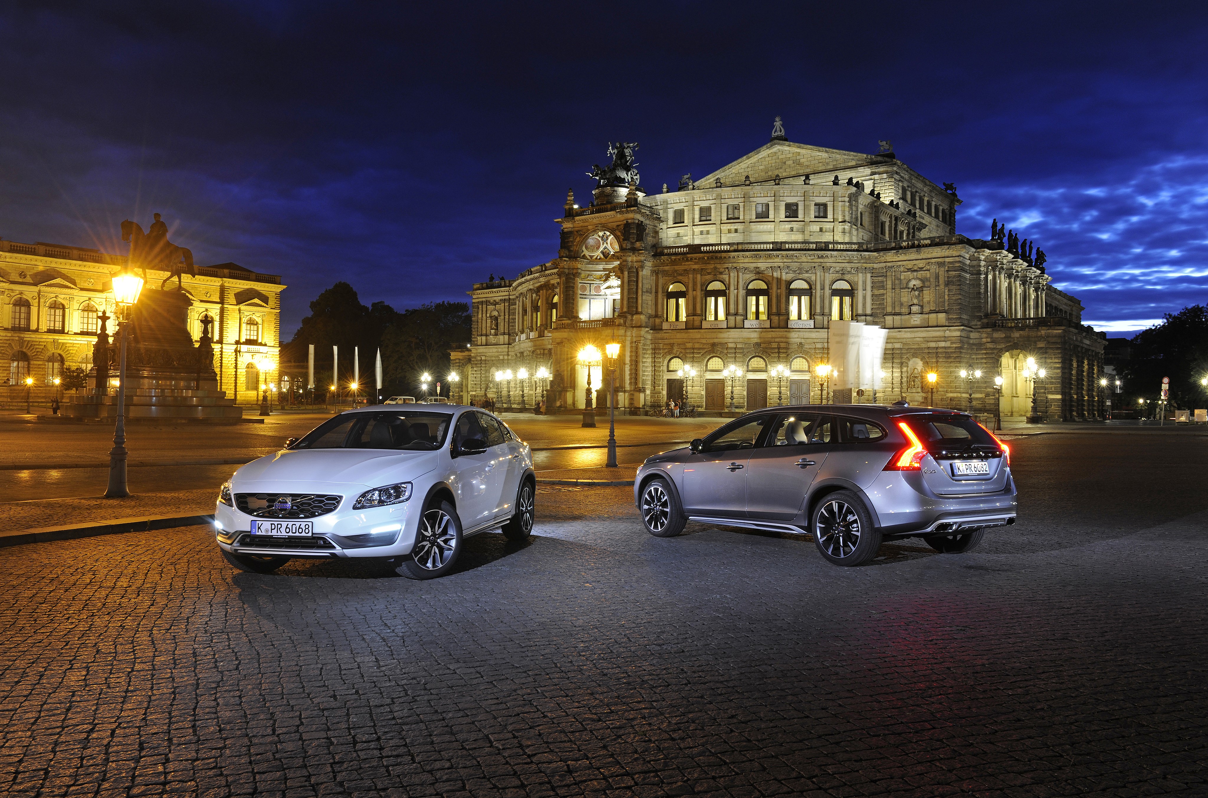 Two Volvo cars parked at night in front of a building HD Wallpaper