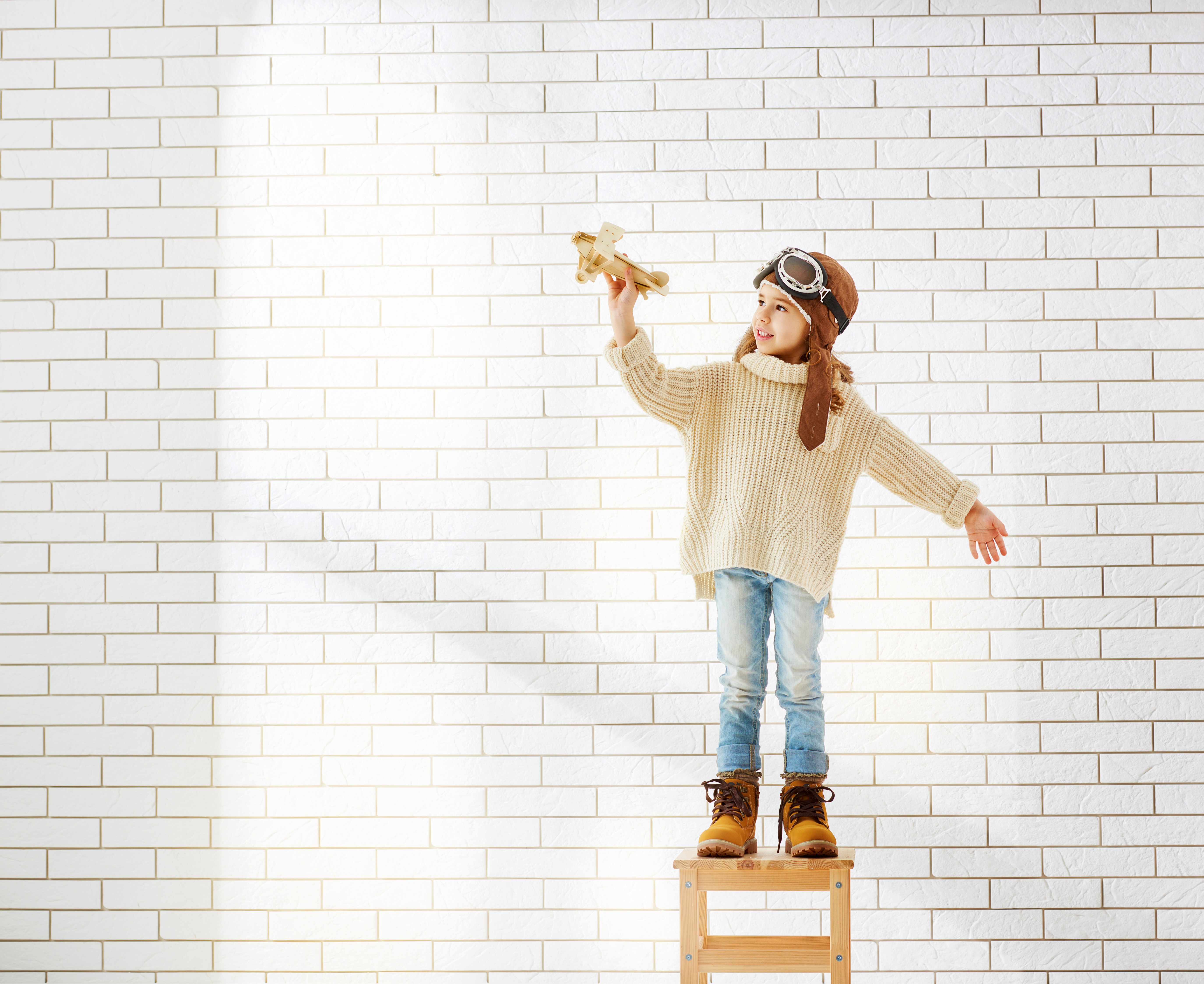 Girl in pilot hat holding toy airplane HD Wallpaper