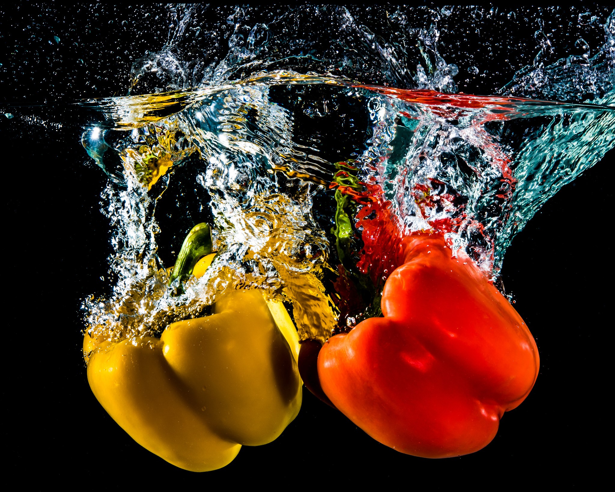Red and yellow bell peppers splashing into water HD Wallpaper