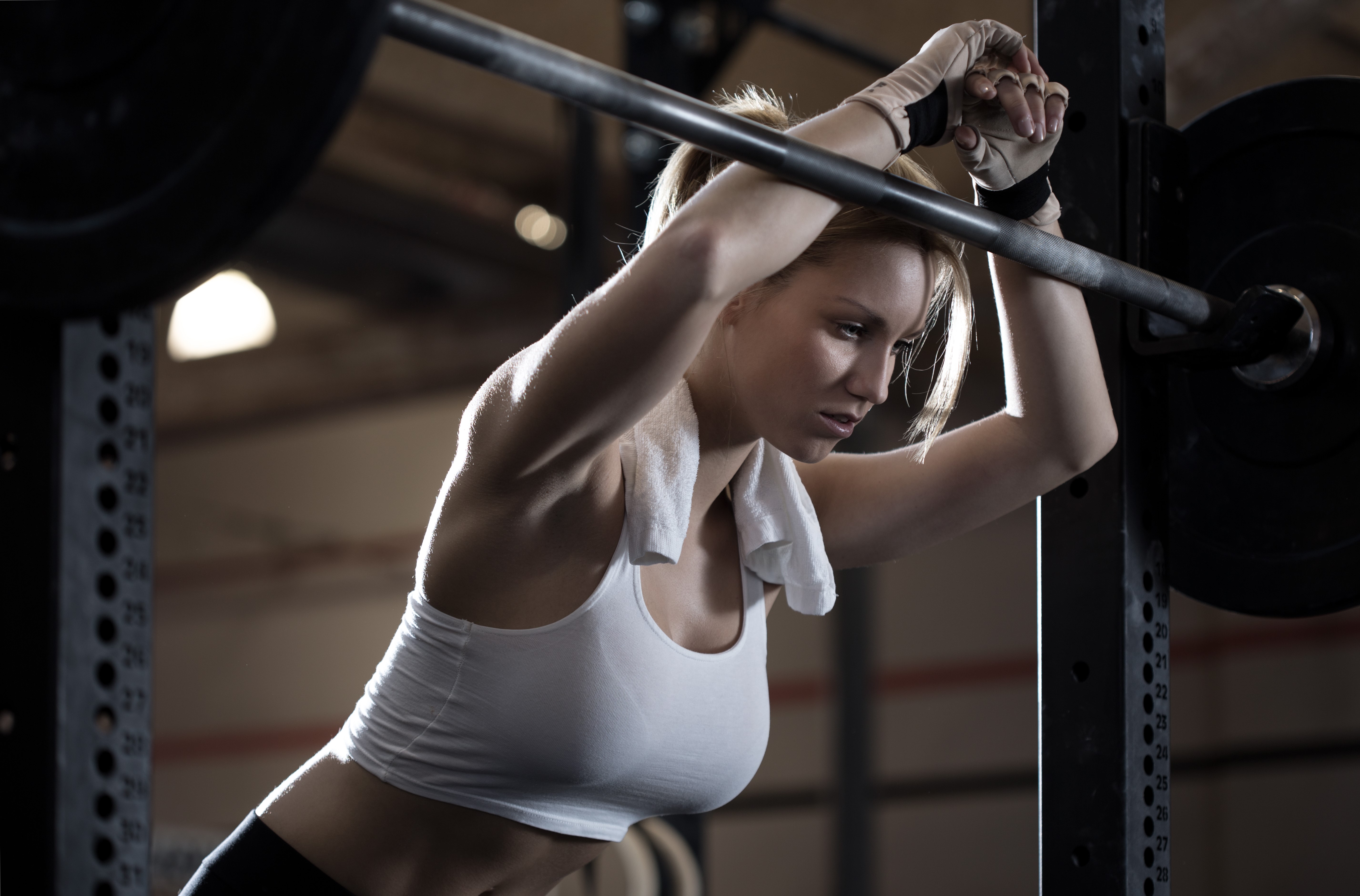 Woman resting on barbell in gym HD Wallpaper