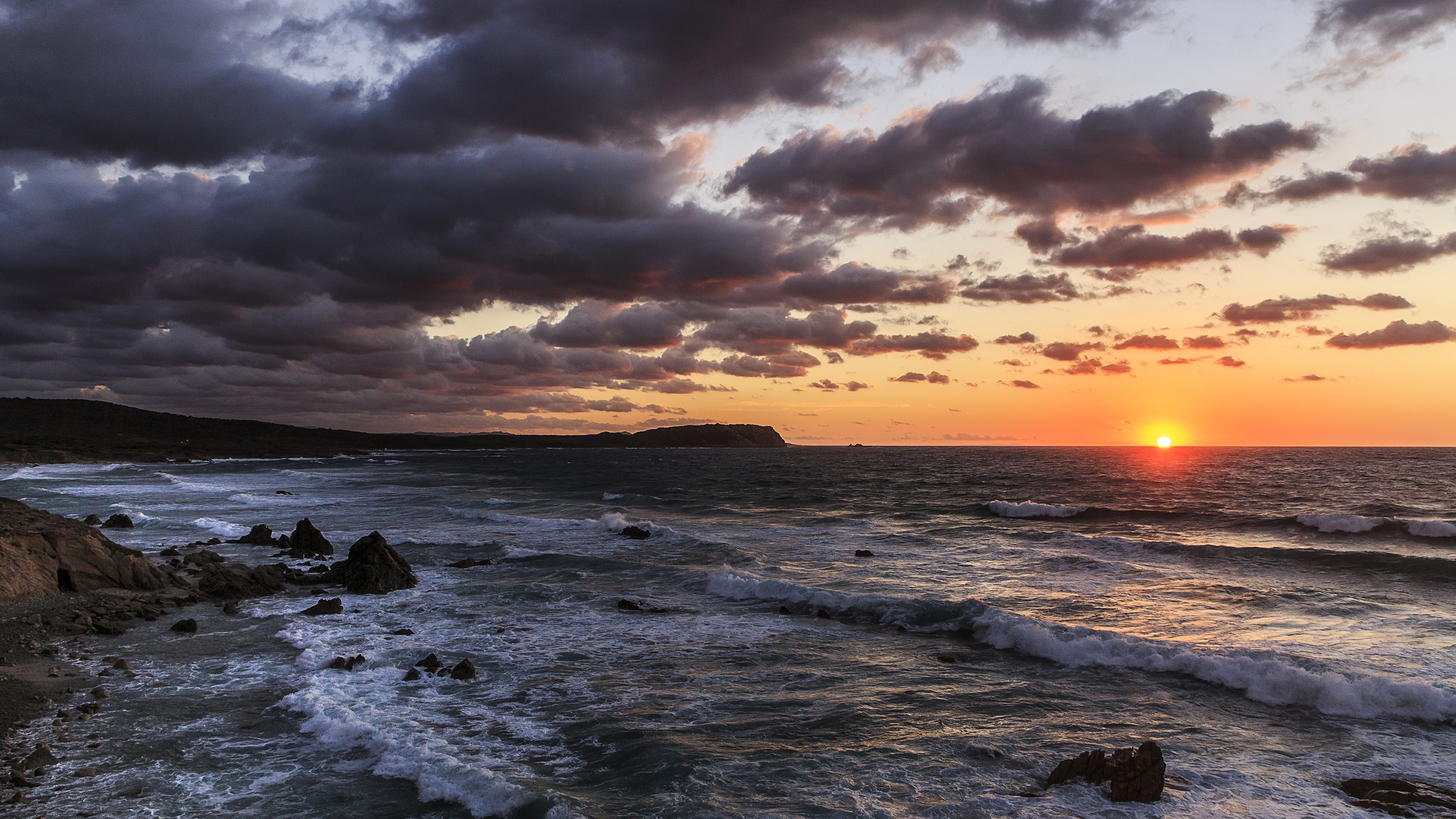Sunset over the sea with dark clouds in Aglientu, Sardinia HD Wallpaper