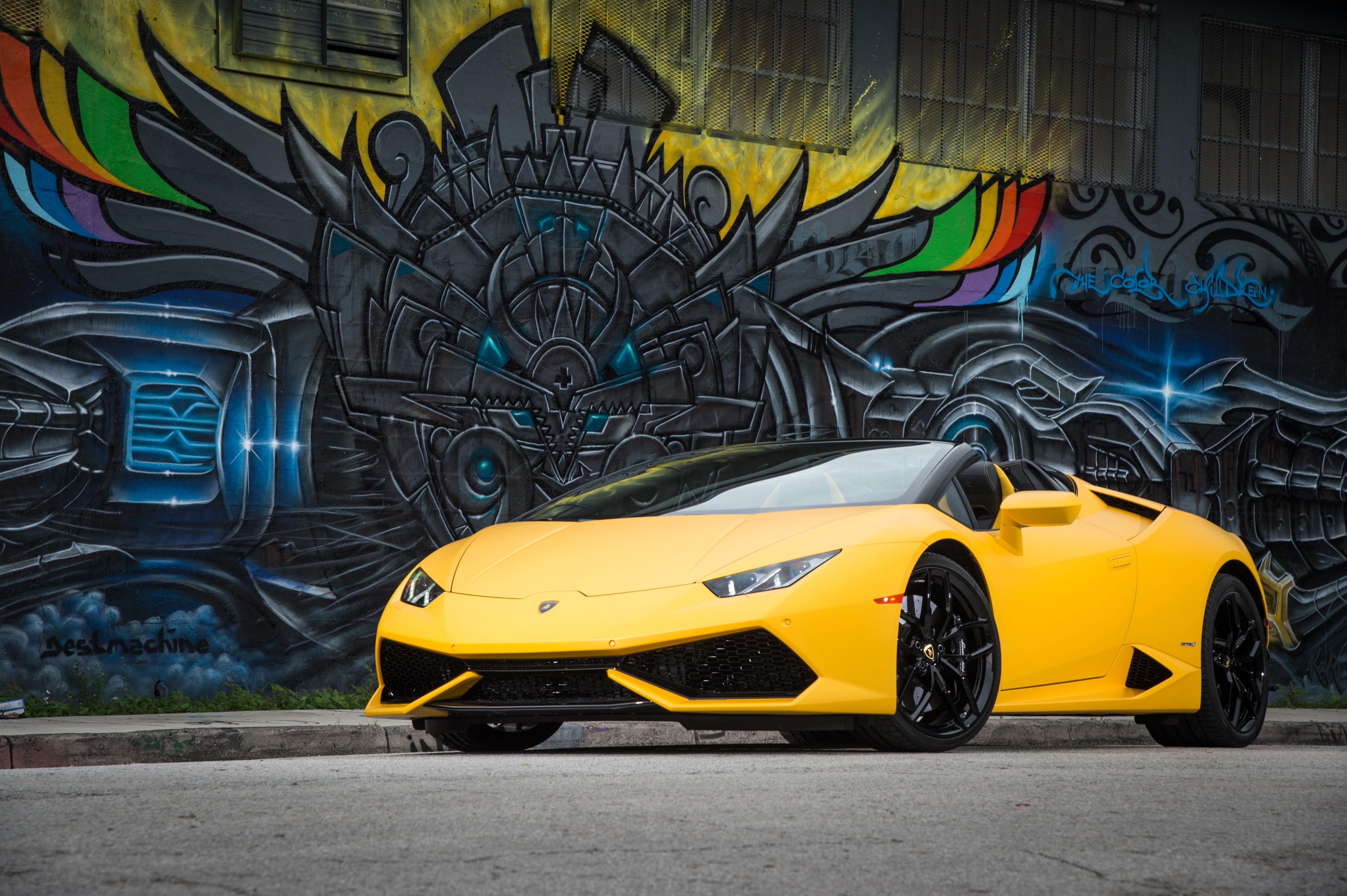 Yellow Lamborghini Huracan parked by graffiti wall HD Wallpaper