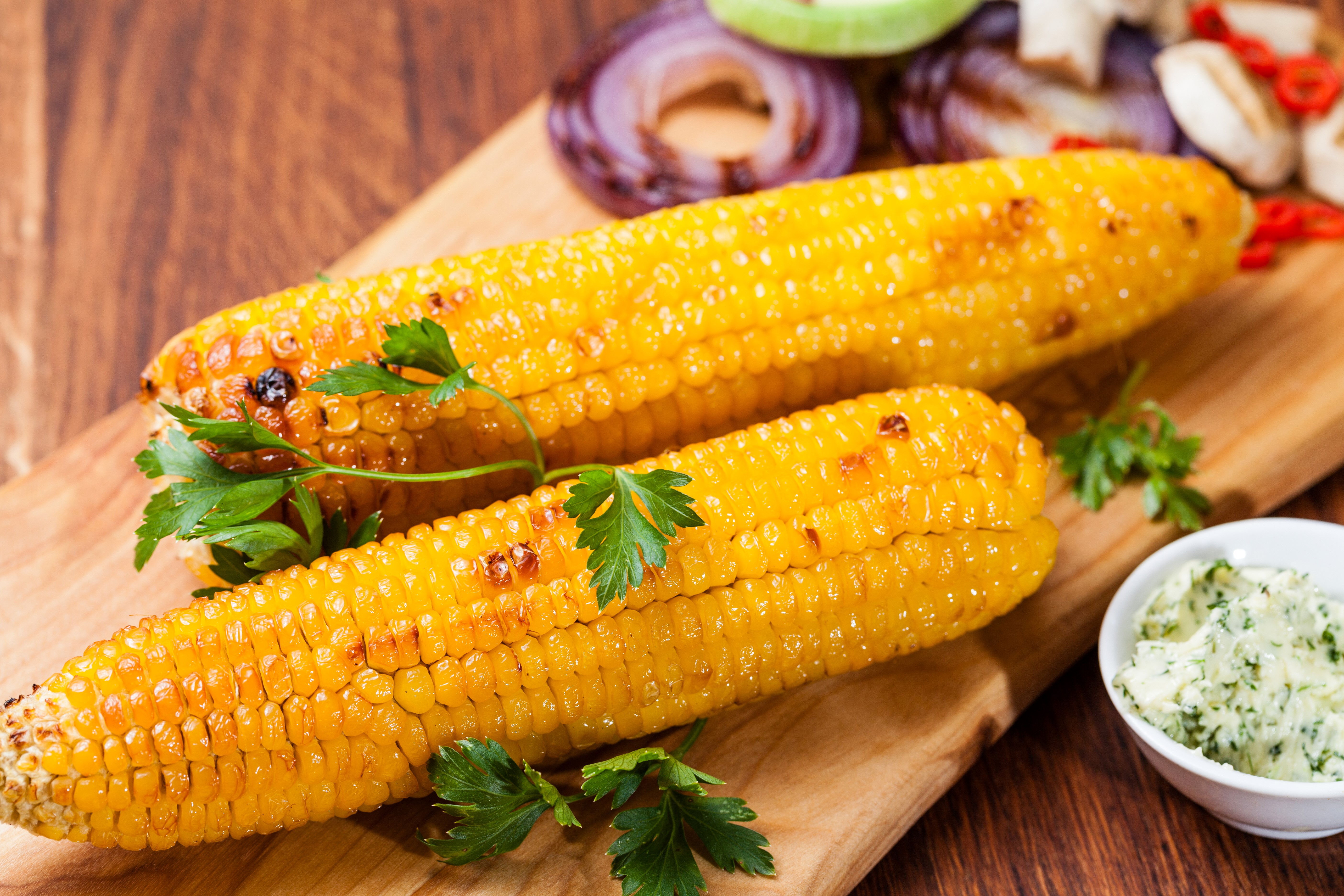Two ears of grilled corn with parsley and butter HD Wallpaper