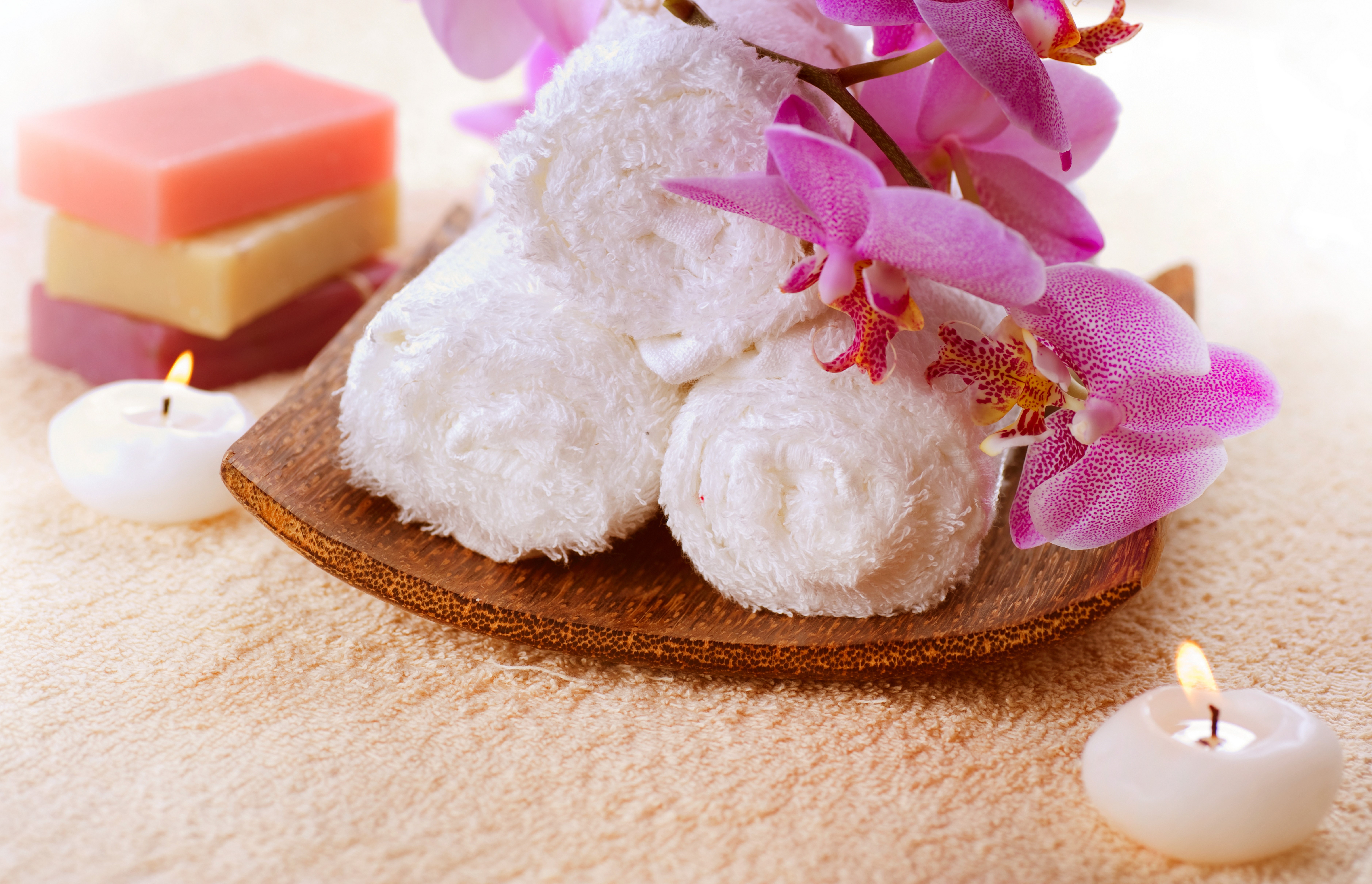 Spa setting with towels, soaps, orchids, and candles HD Wallpaper