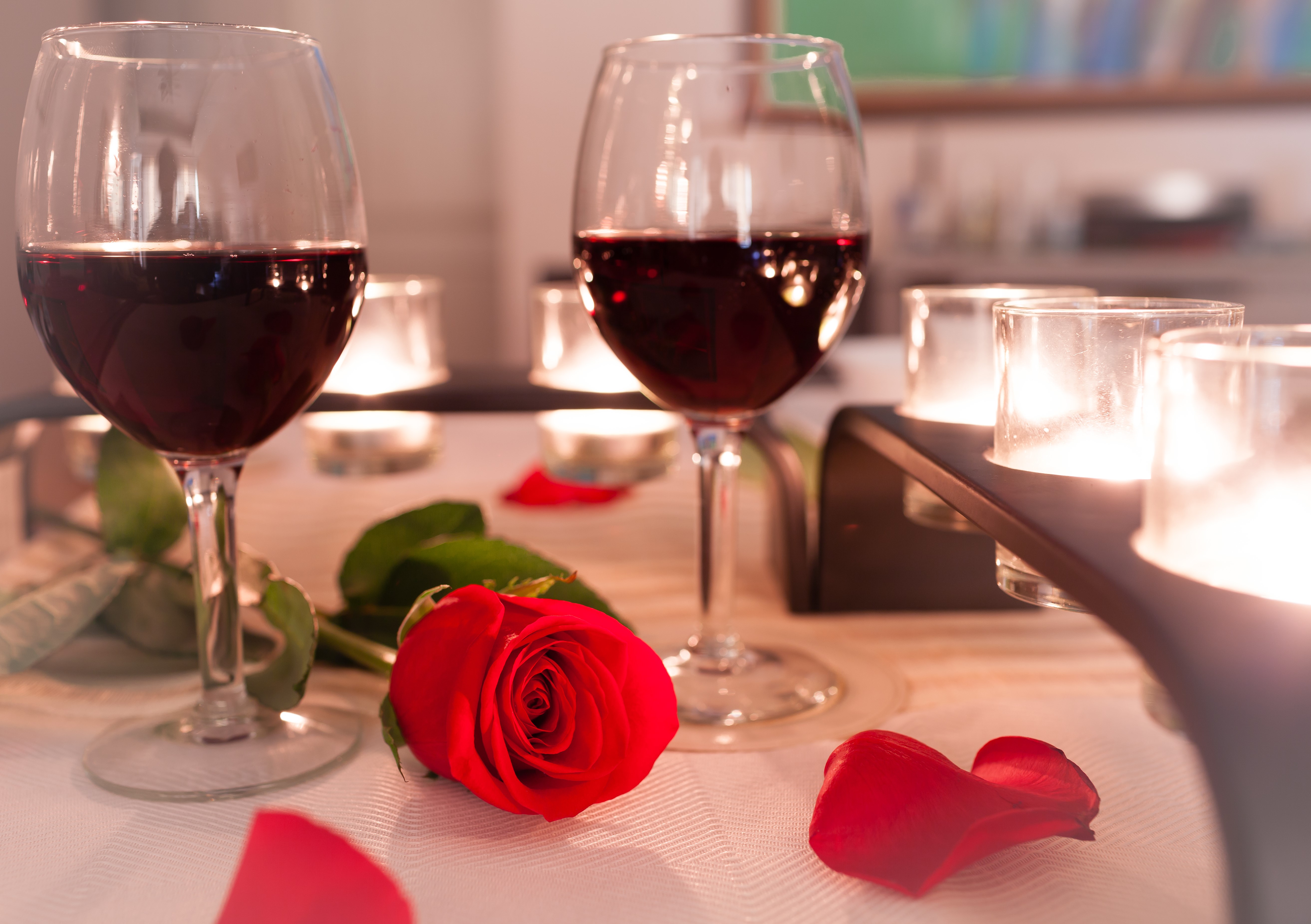 Red wine and rose on a table with candles HD Wallpaper