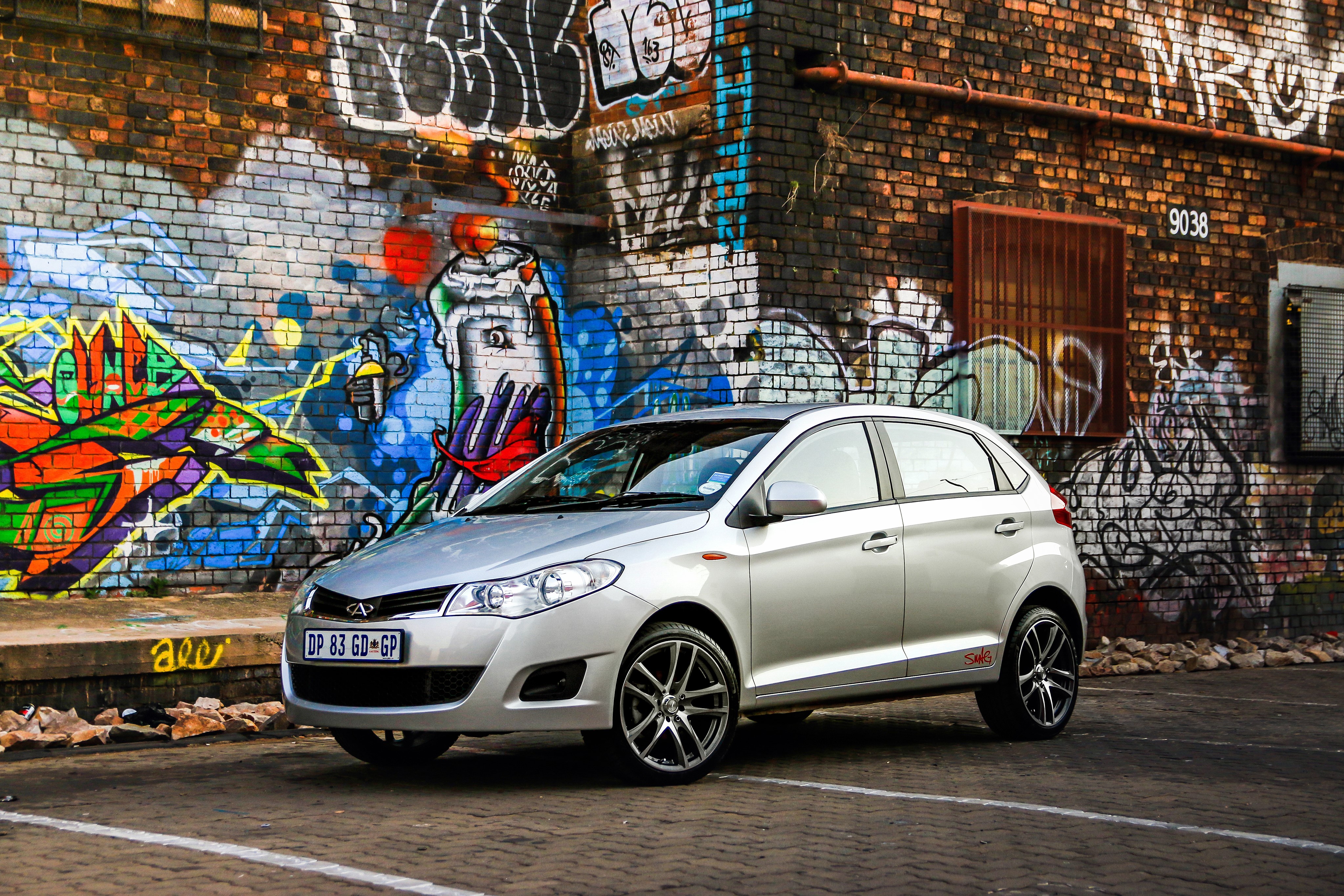 Chery car parked in front of graffiti wall HD Wallpaper