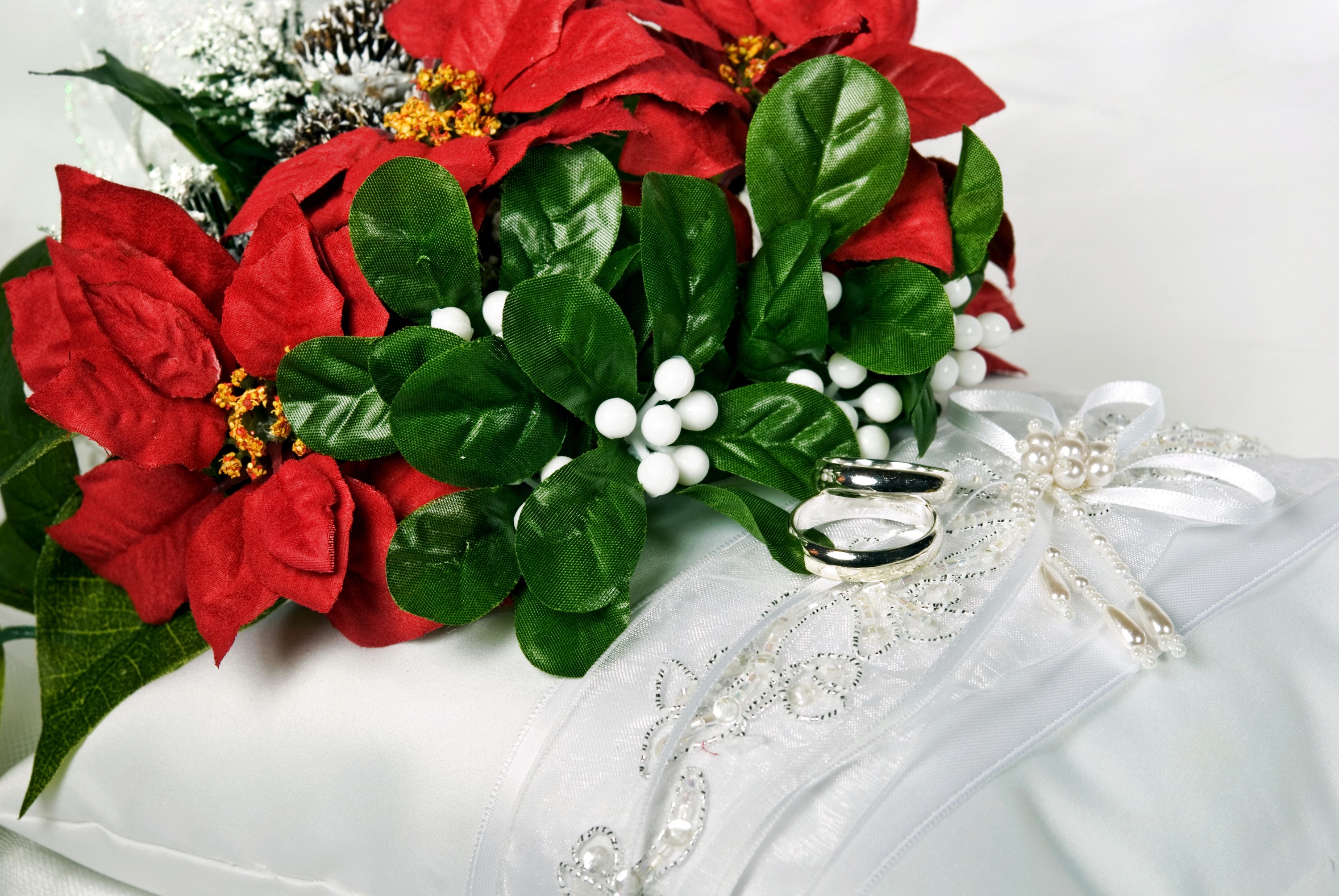 Wedding rings on a pillow with poinsettias HD Wallpaper