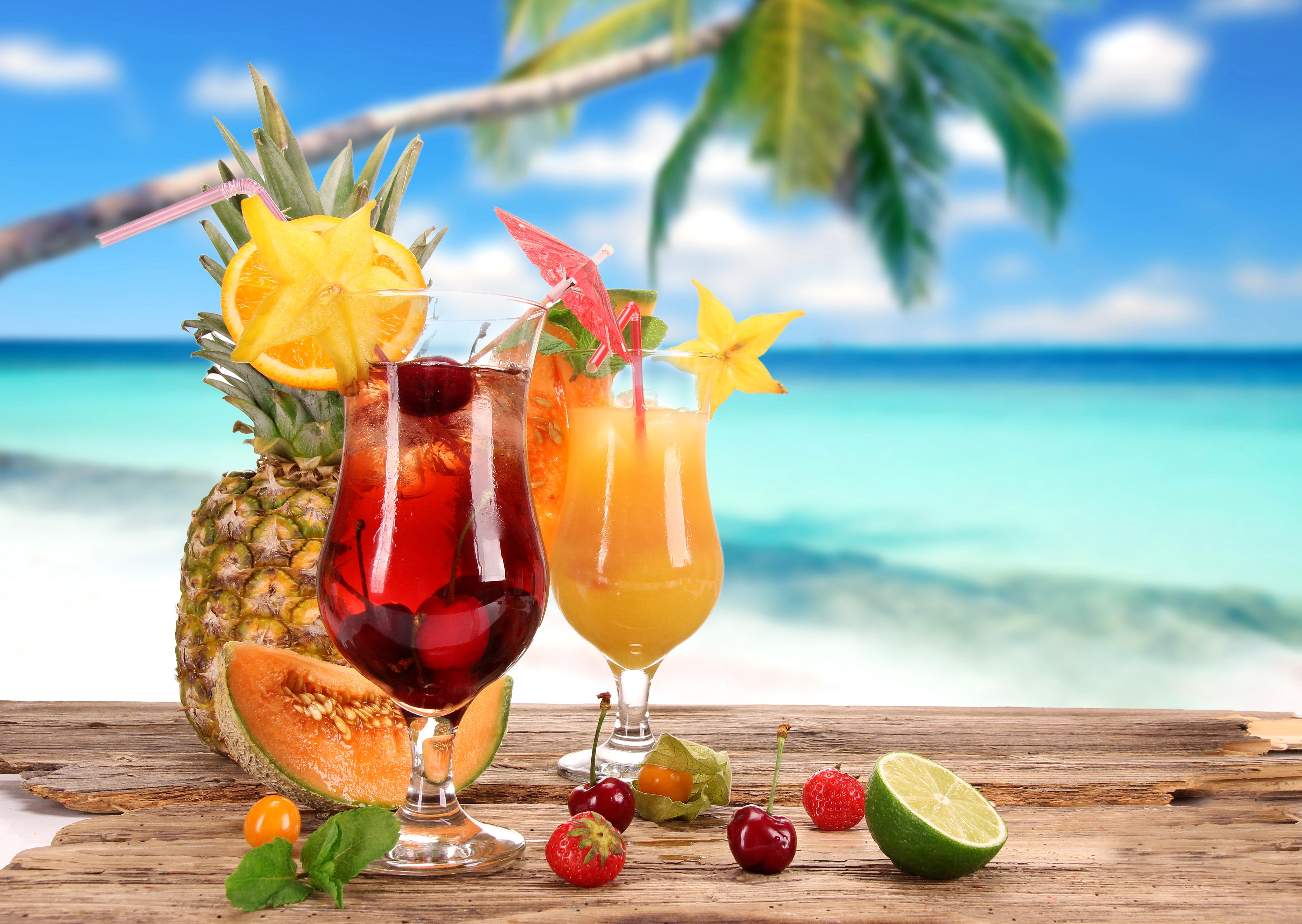 Two tropical cocktails with fruits on a beach HD Wallpaper
