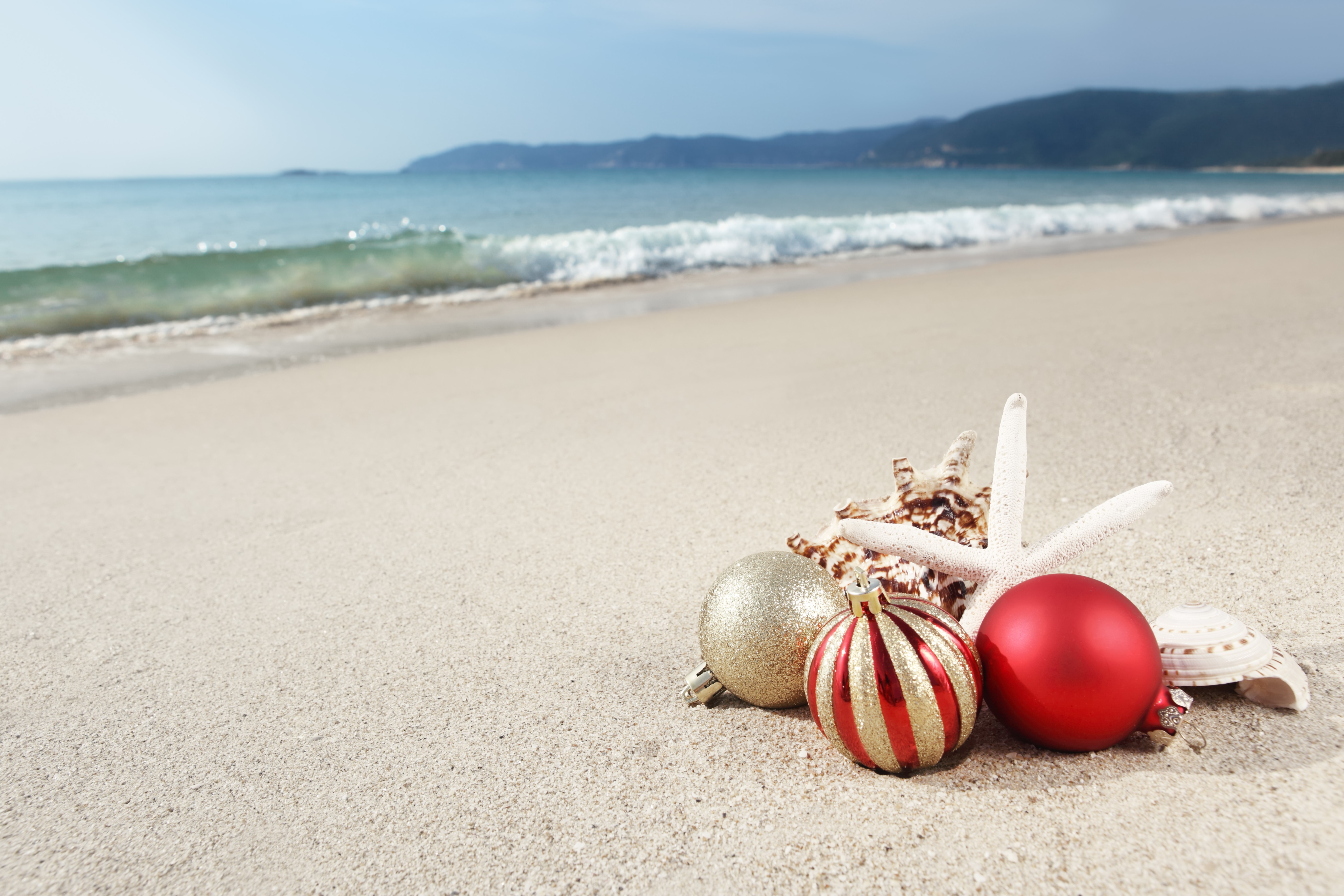 Christmas ornaments and seashells on a beach HD Wallpaper
