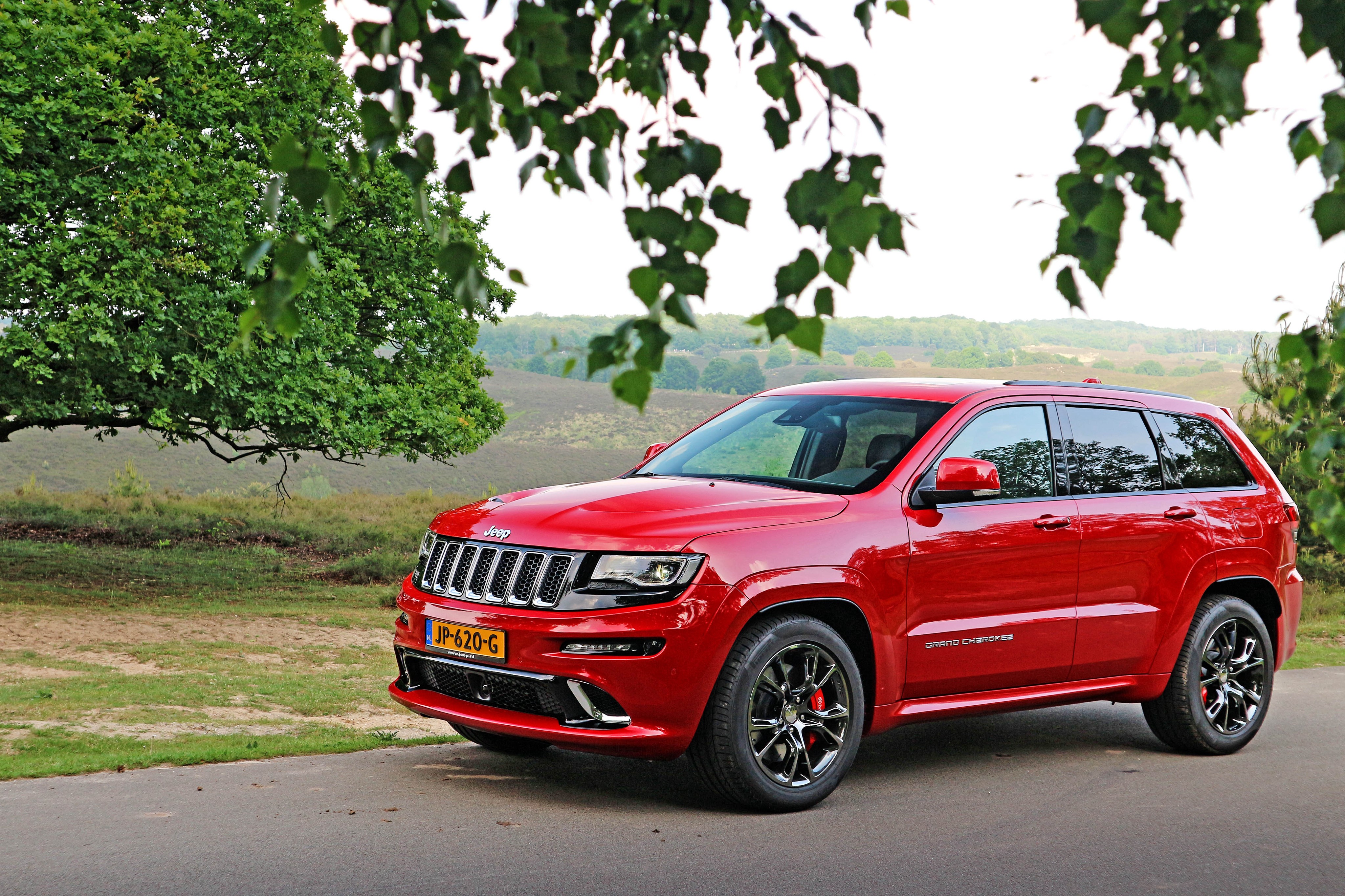Red Jeep Grand Cherokee parked on a road HD Wallpaper