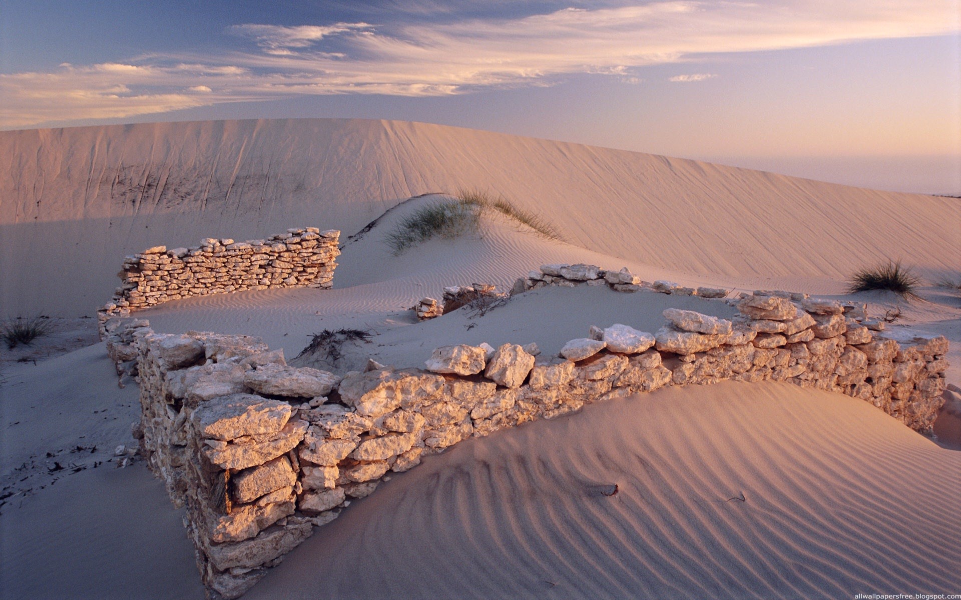 Stone ruins on sand dunes at sunset HD Wallpaper