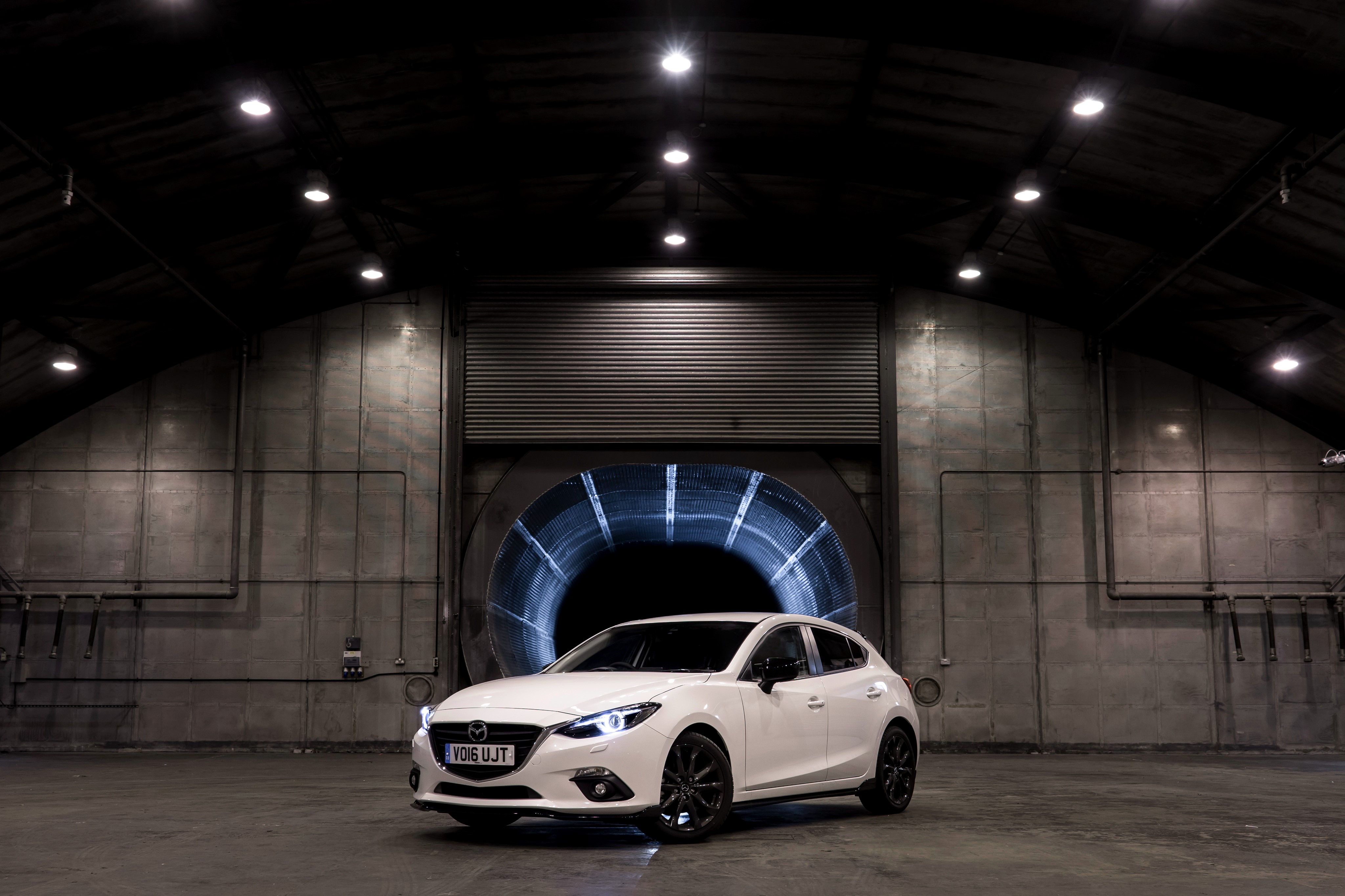 White 2016 Mazda 3 Sport in a large industrial building HD Wallpaper