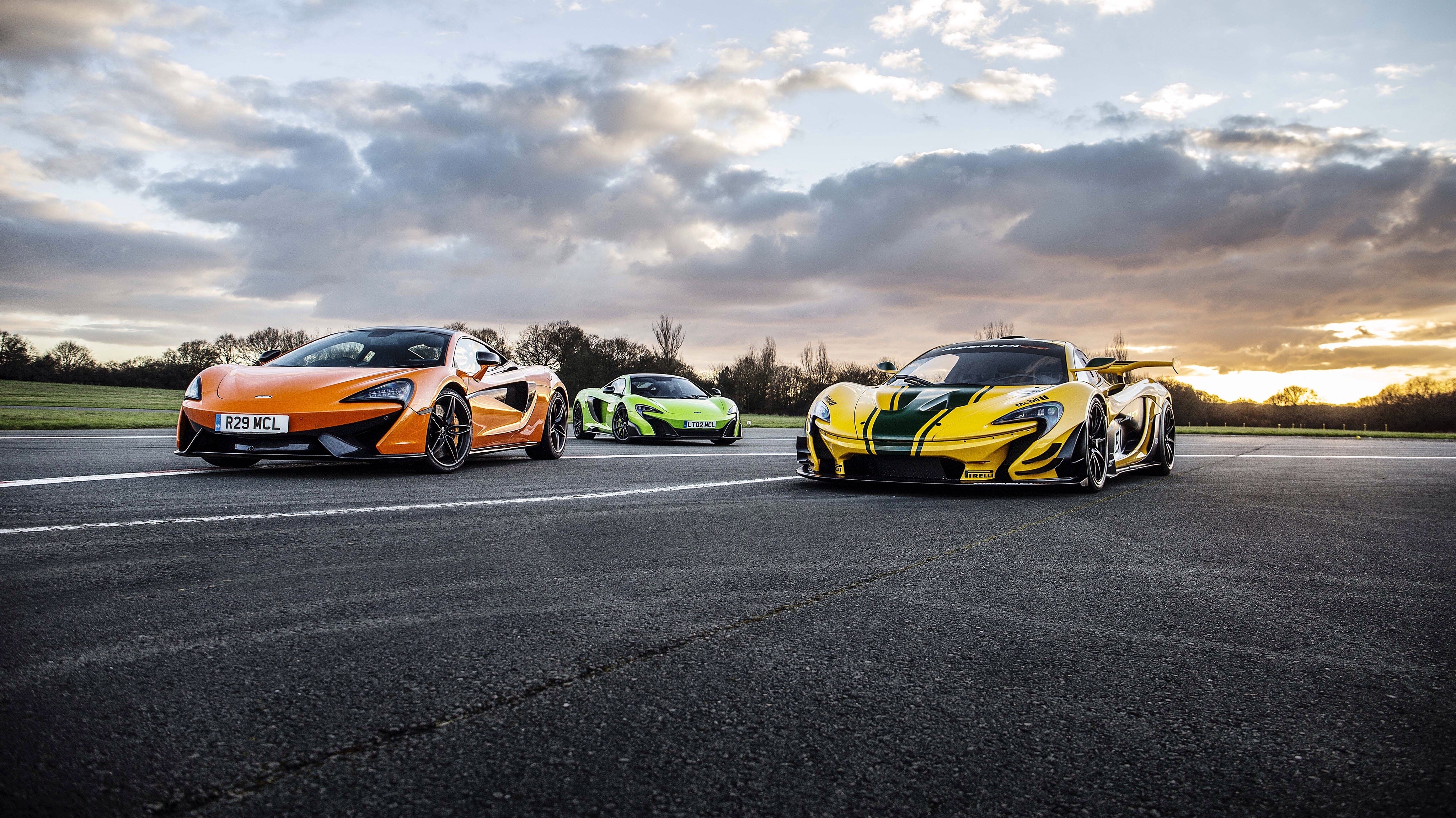 Three McLaren Sports Cars on a Racetrack HD Wallpaper