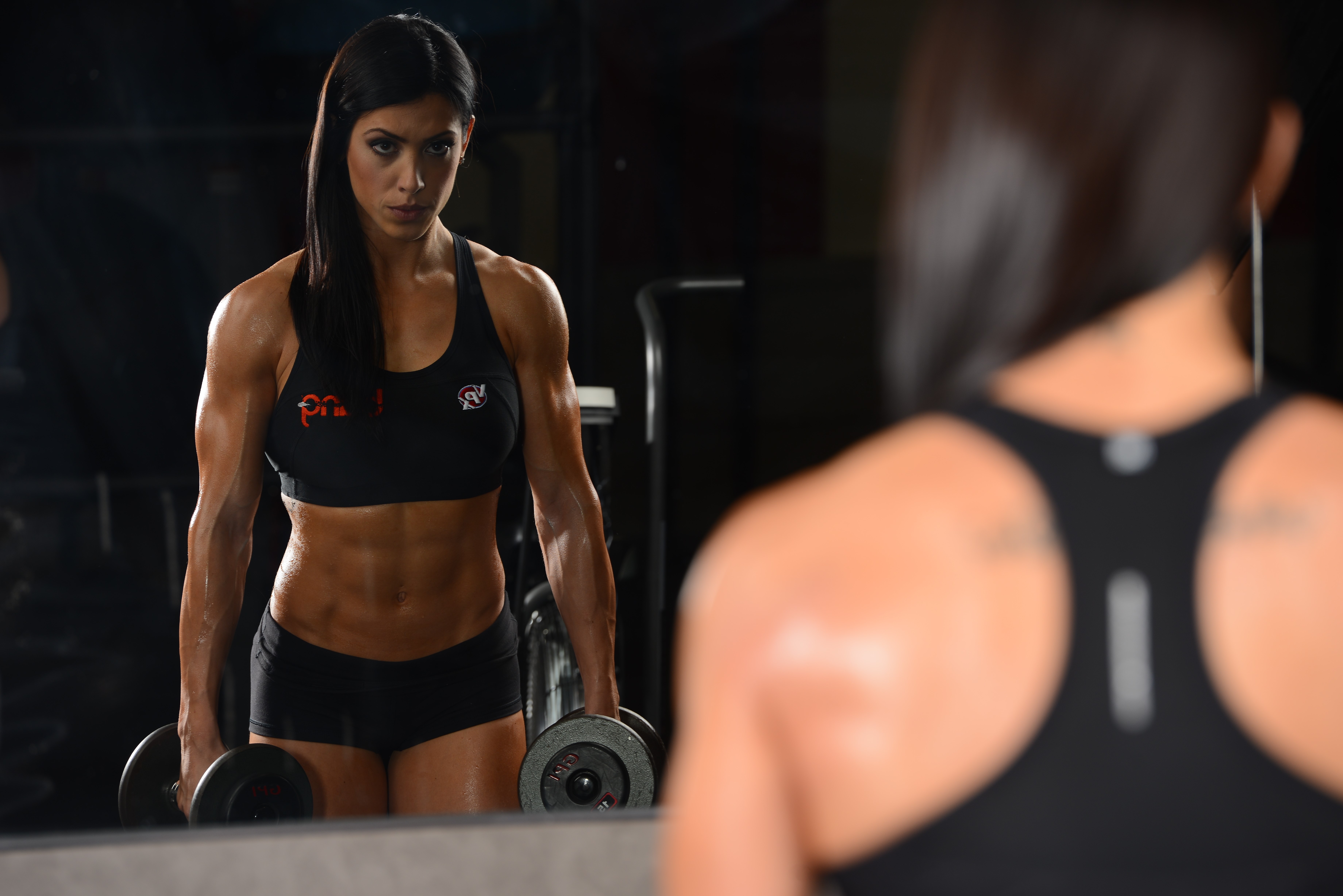 Woman with dumbbells in a gym, reflection in mirror HD Wallpaper