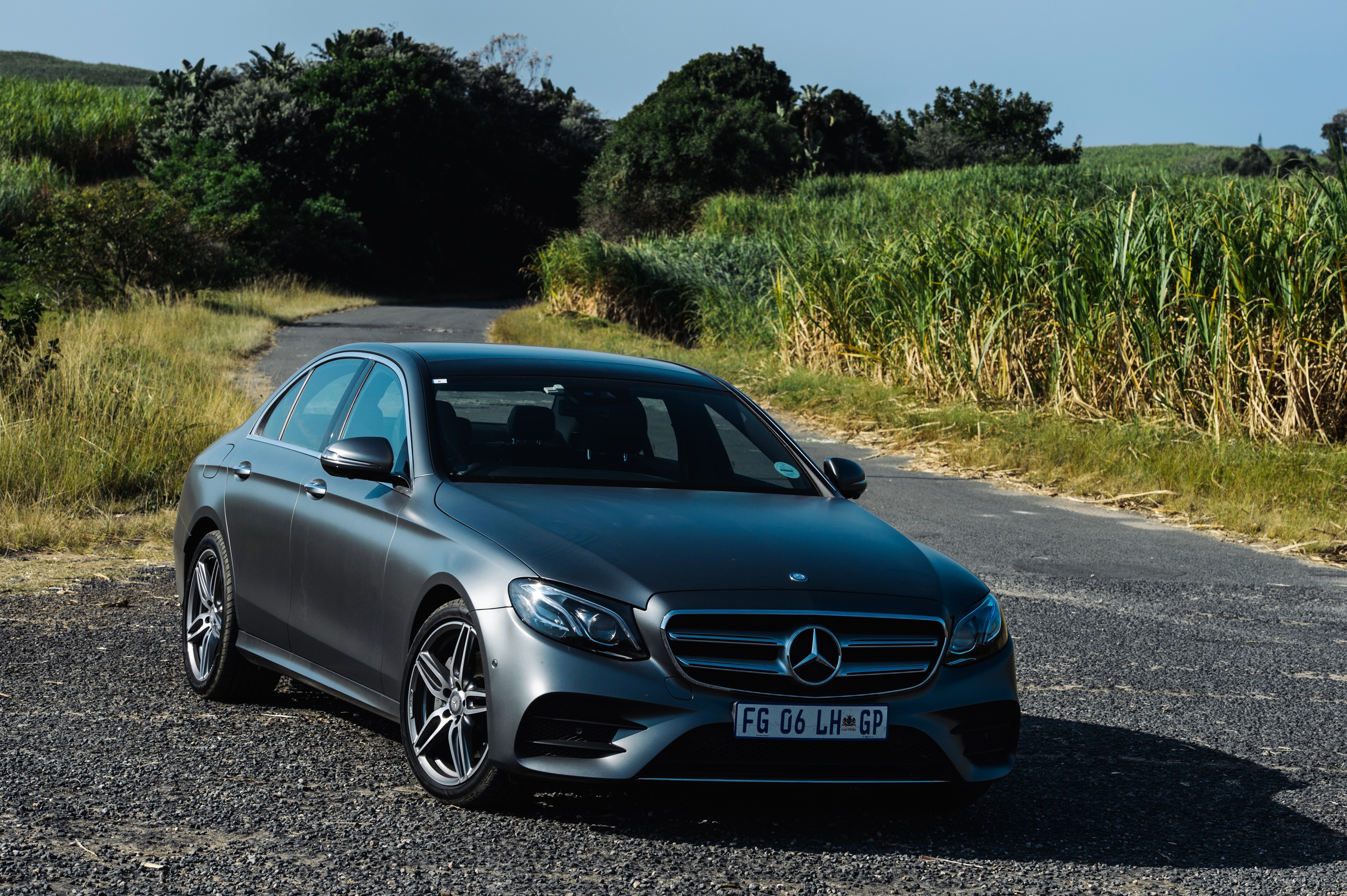 Mercedes-Benz E 220 d AMG Line sedan on a rural road HD Wallpaper