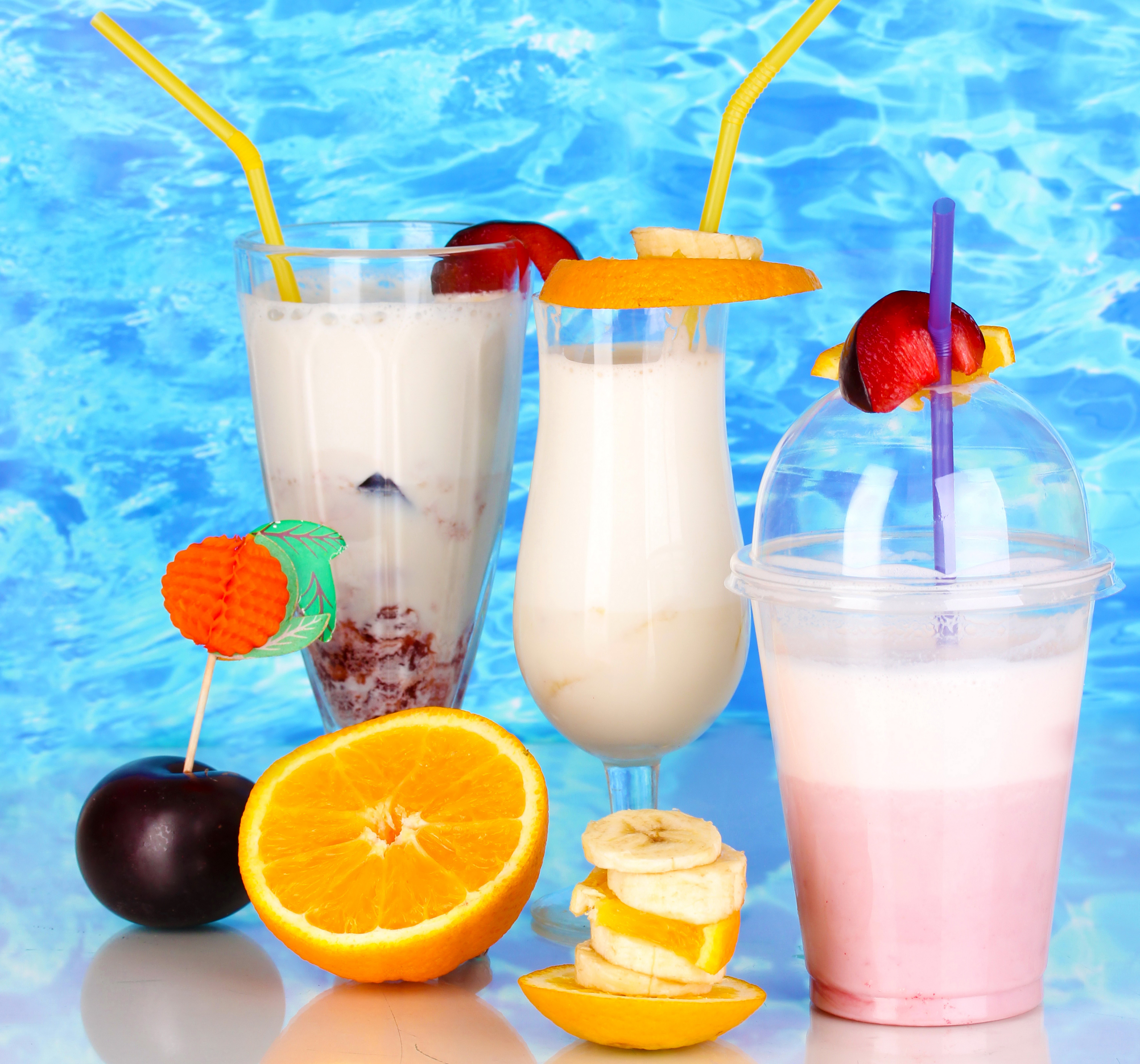 Three cocktails with fruits and straws on a blue background HD Wallpaper