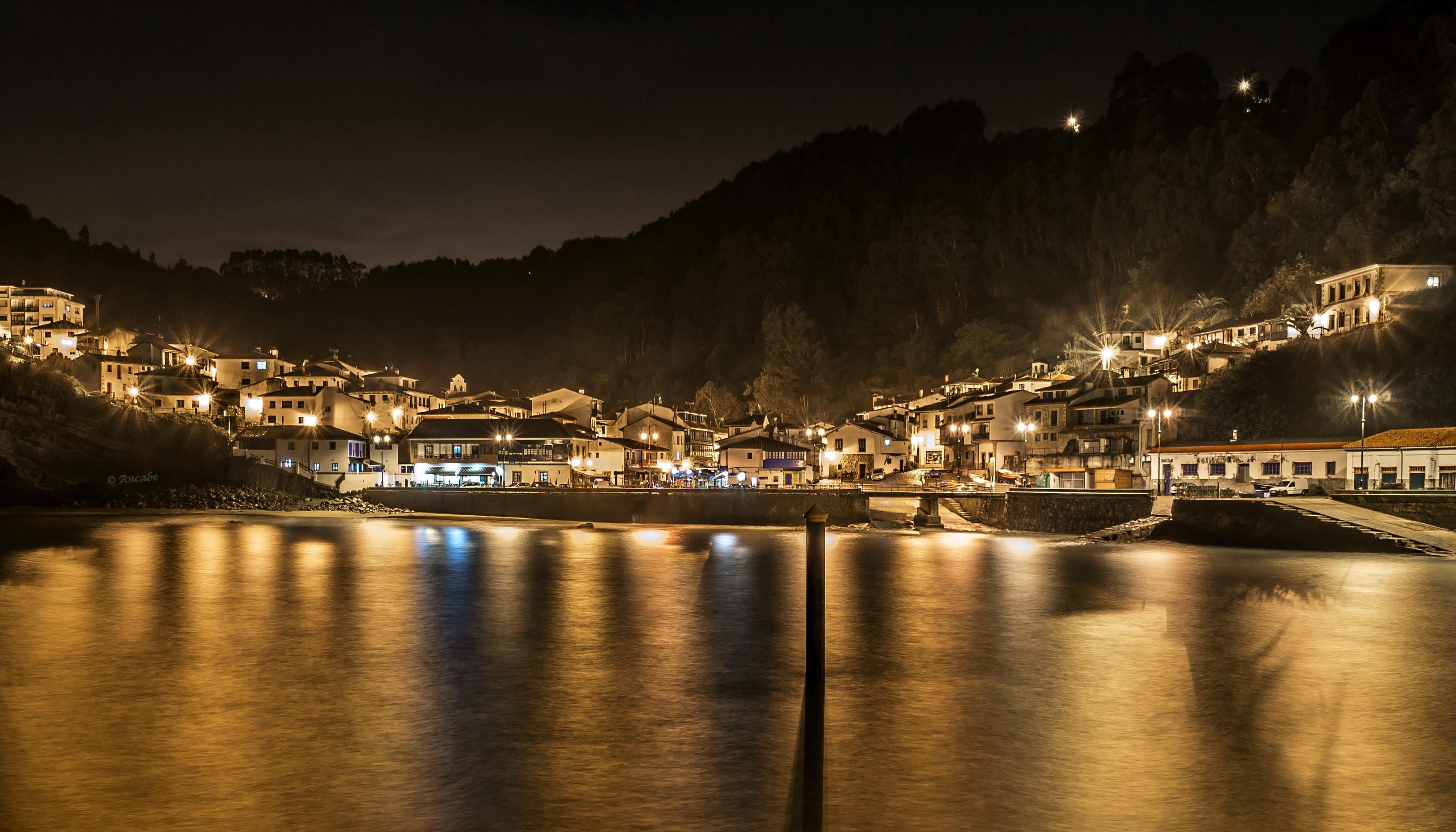 Tazones, Spain at night with illuminated houses and reflections HD Wallpaper