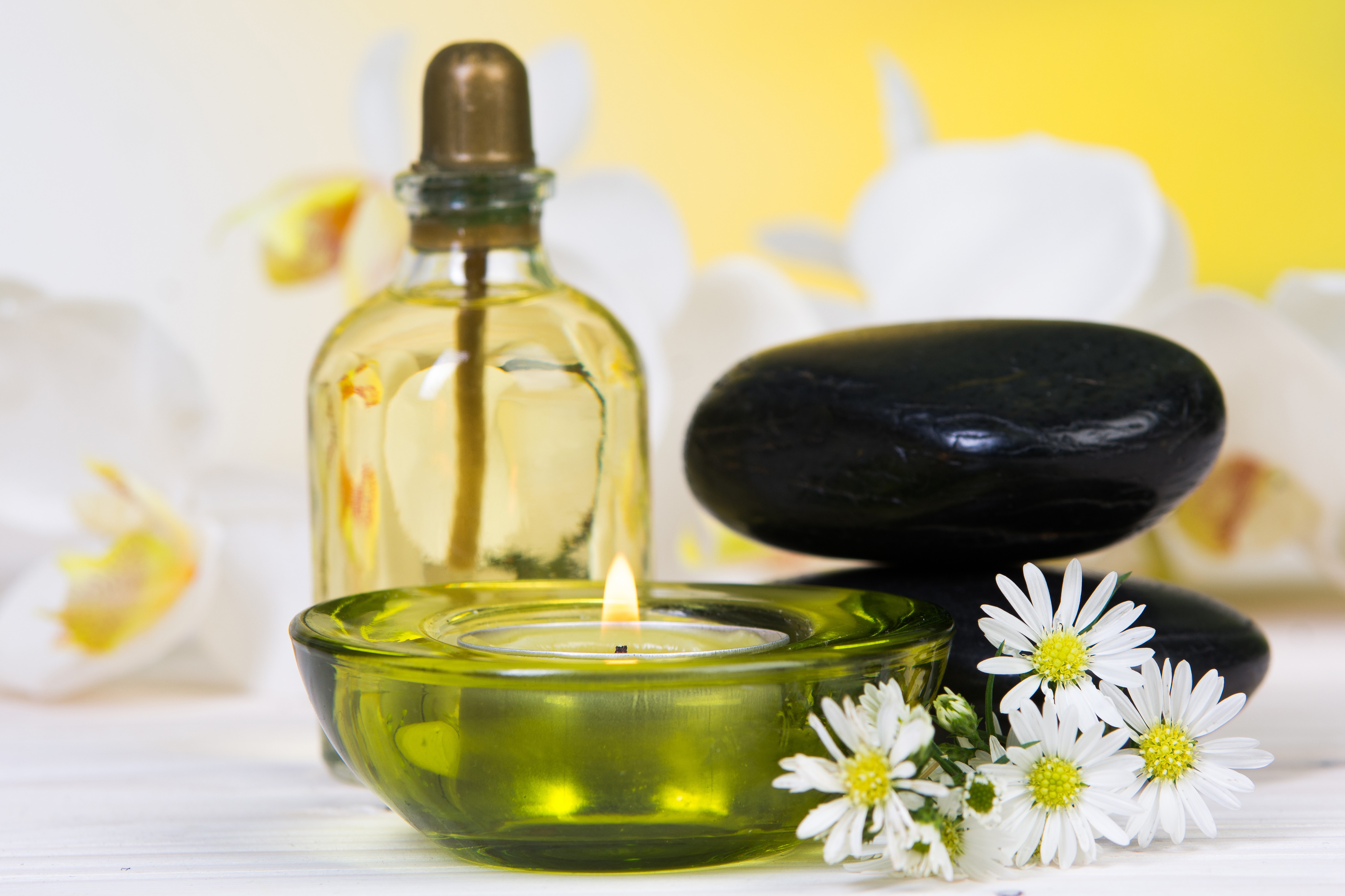 Spa stones, candle, and oil bottle with orchids HD Wallpaper