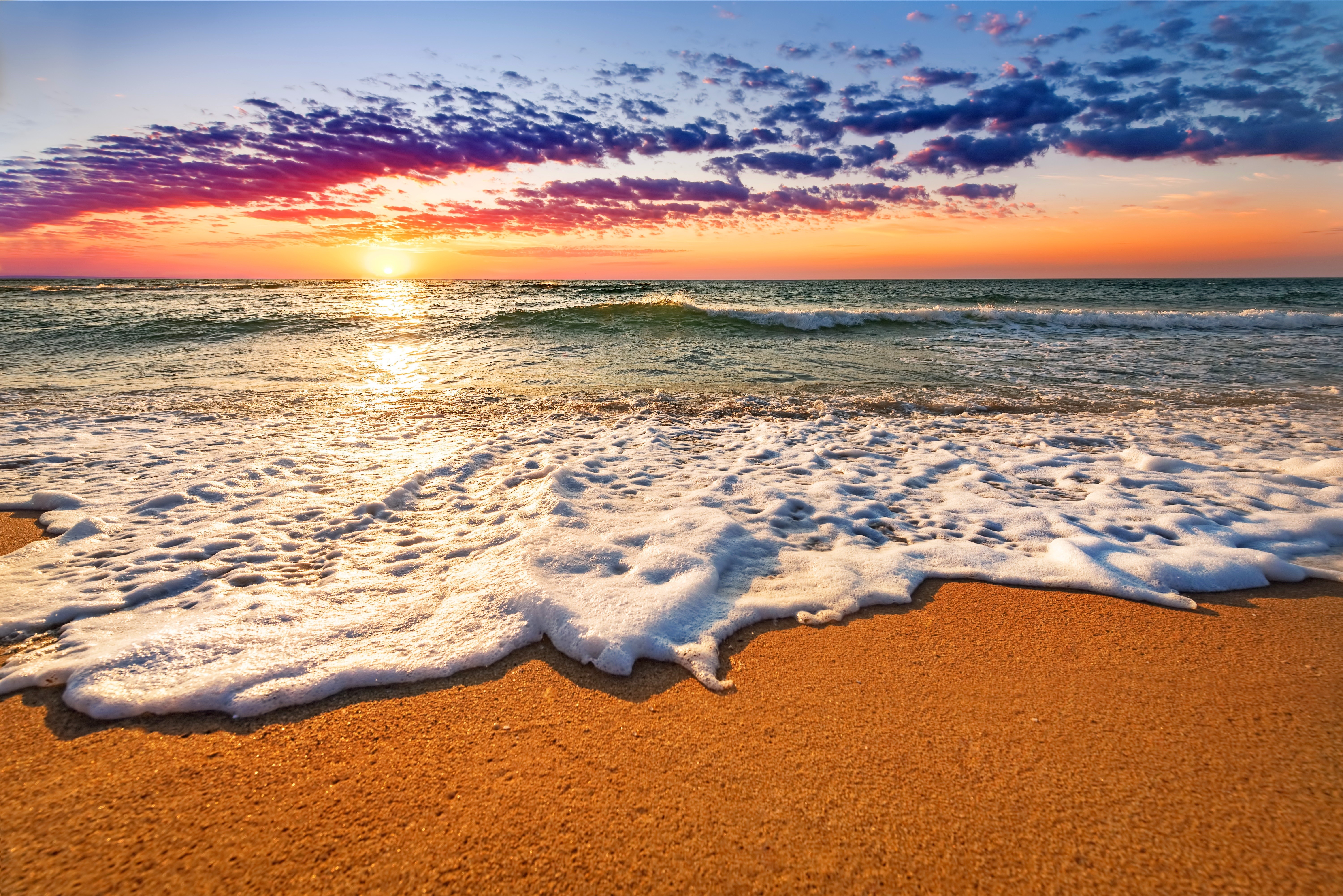 Sunset over the sea with foamy waves on the shore HD Wallpaper