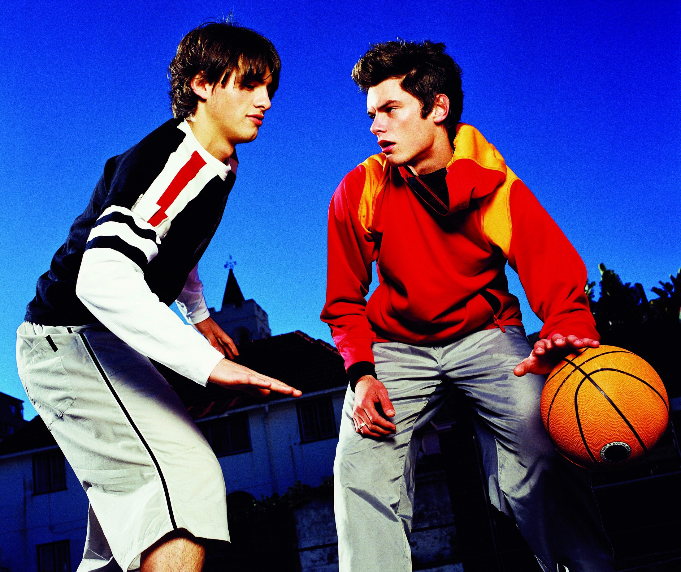 Two young men playing basketball outdoors HD Wallpaper