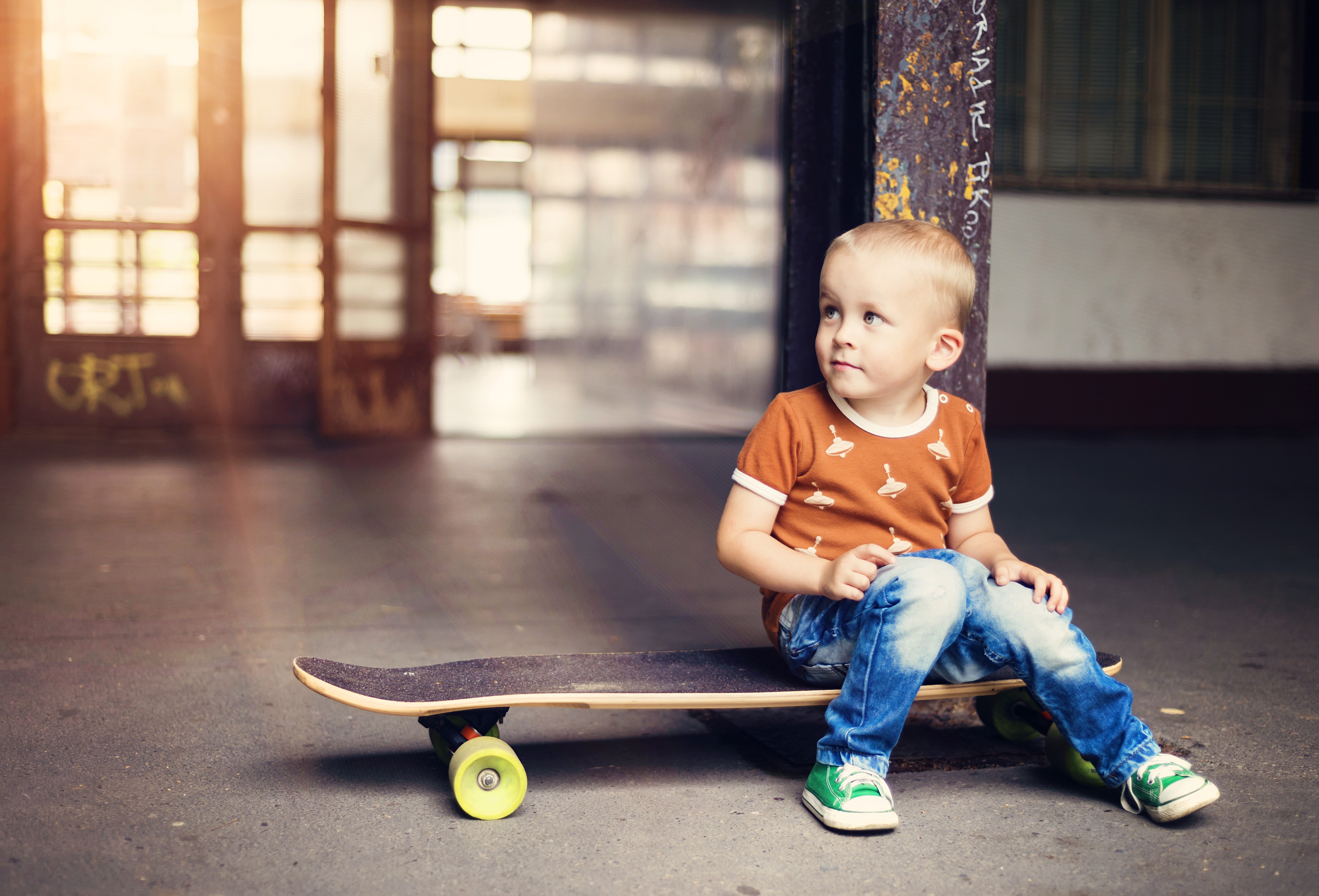 Boy sitting on a skateboard HD Wallpaper
