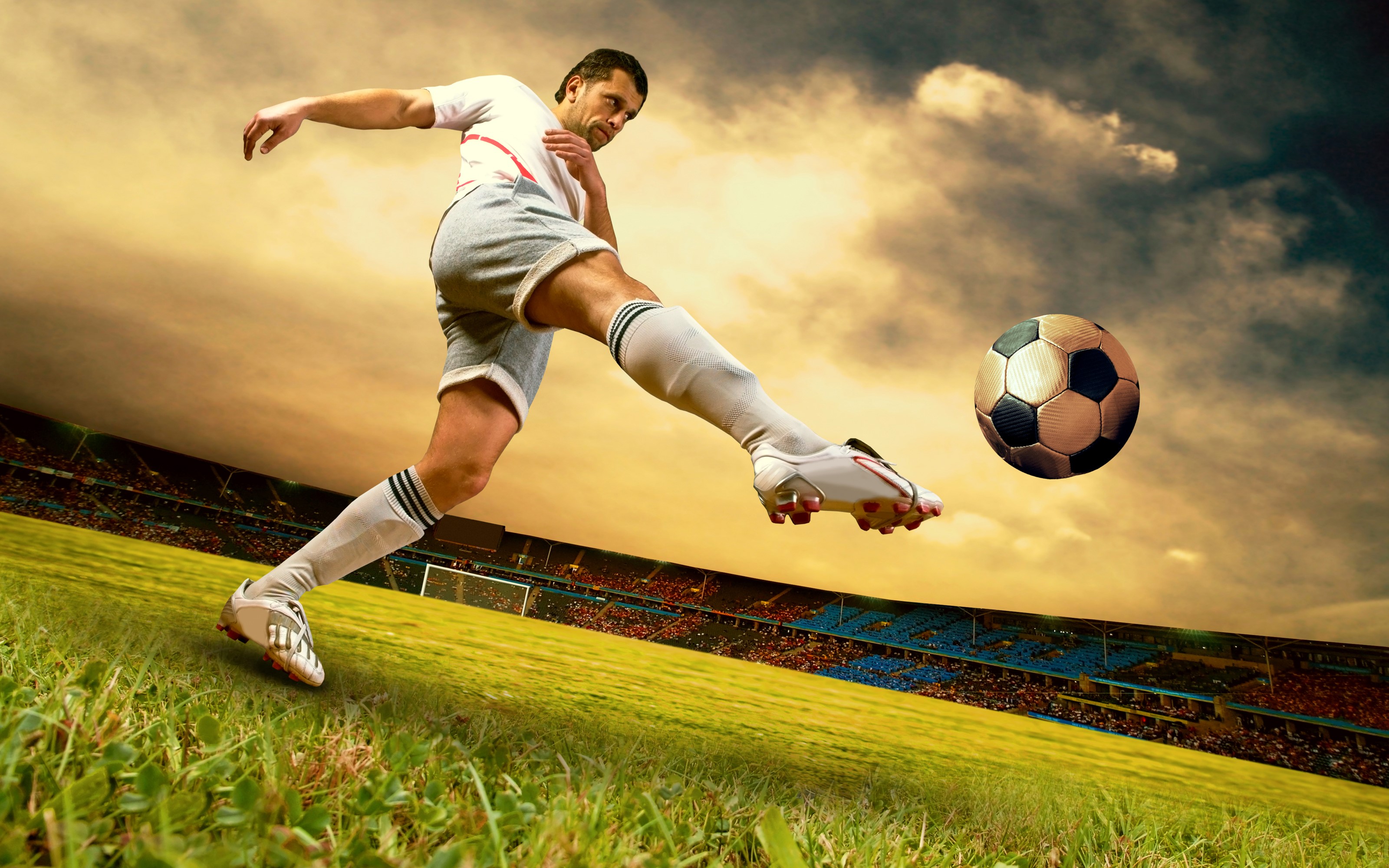 Man kicking a soccer ball in a stadium HD Wallpaper