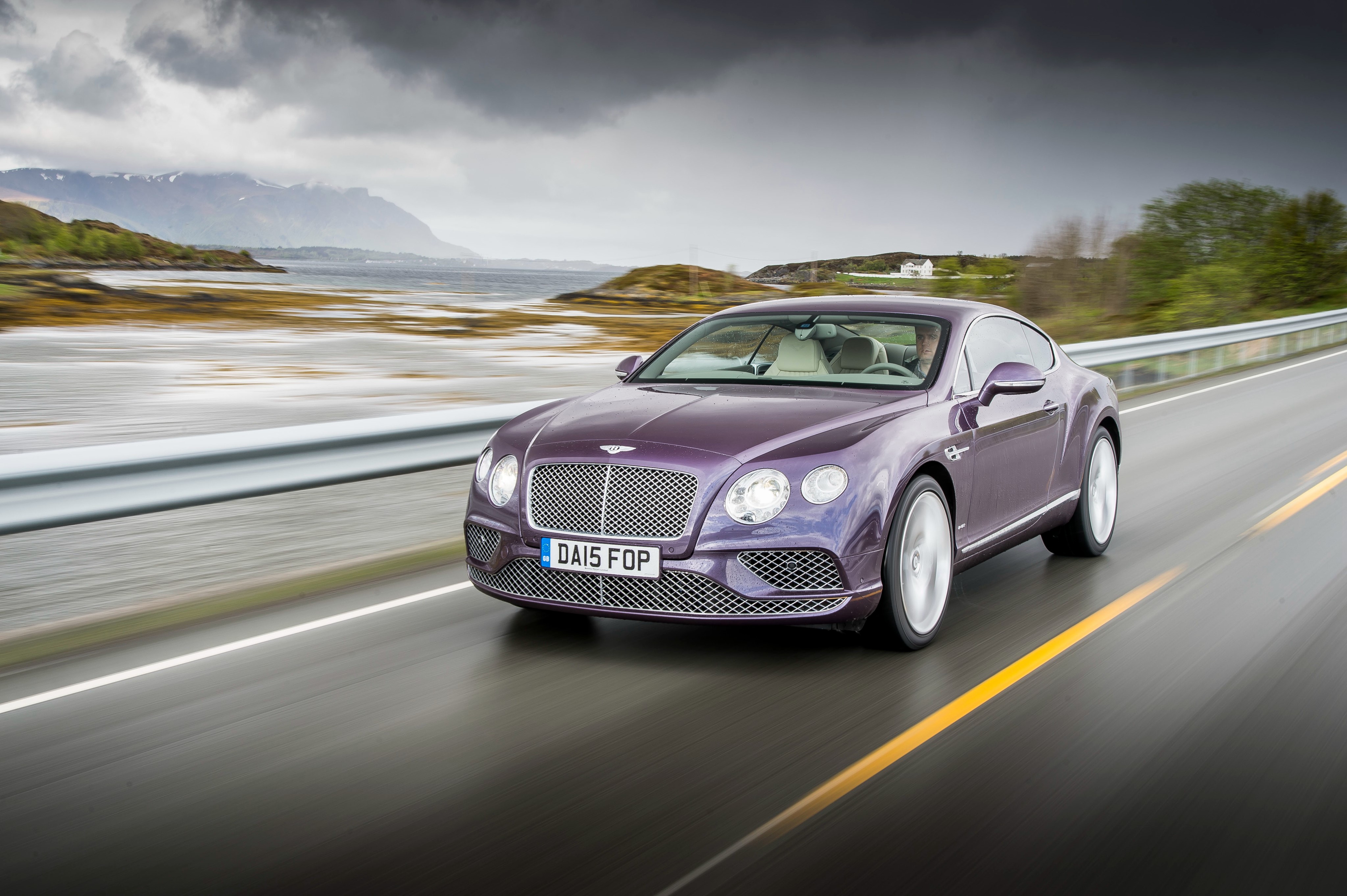 Bentley Continental GT driving on a scenic road HD Wallpaper