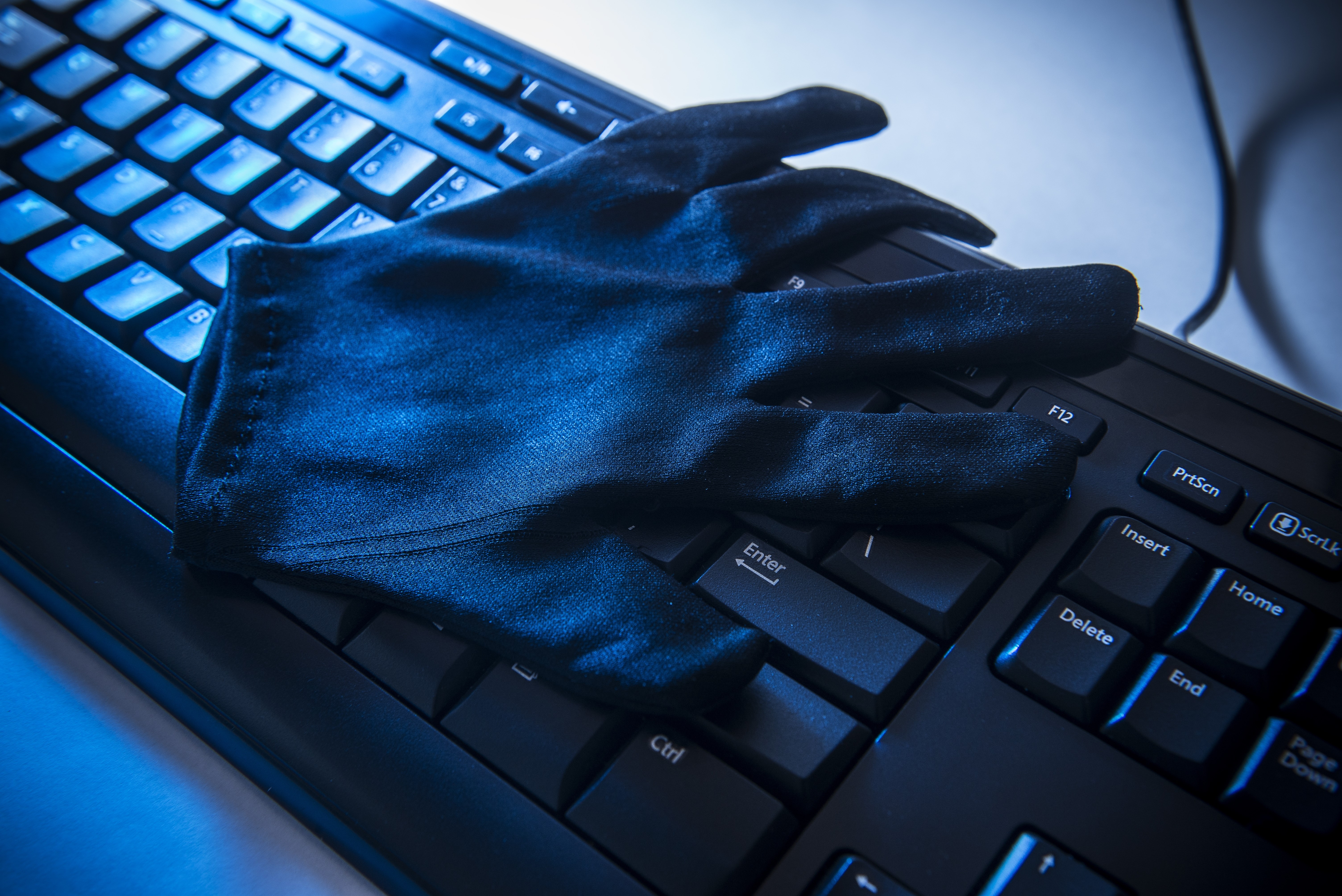 Black glove on a computer keyboard HD Wallpaper