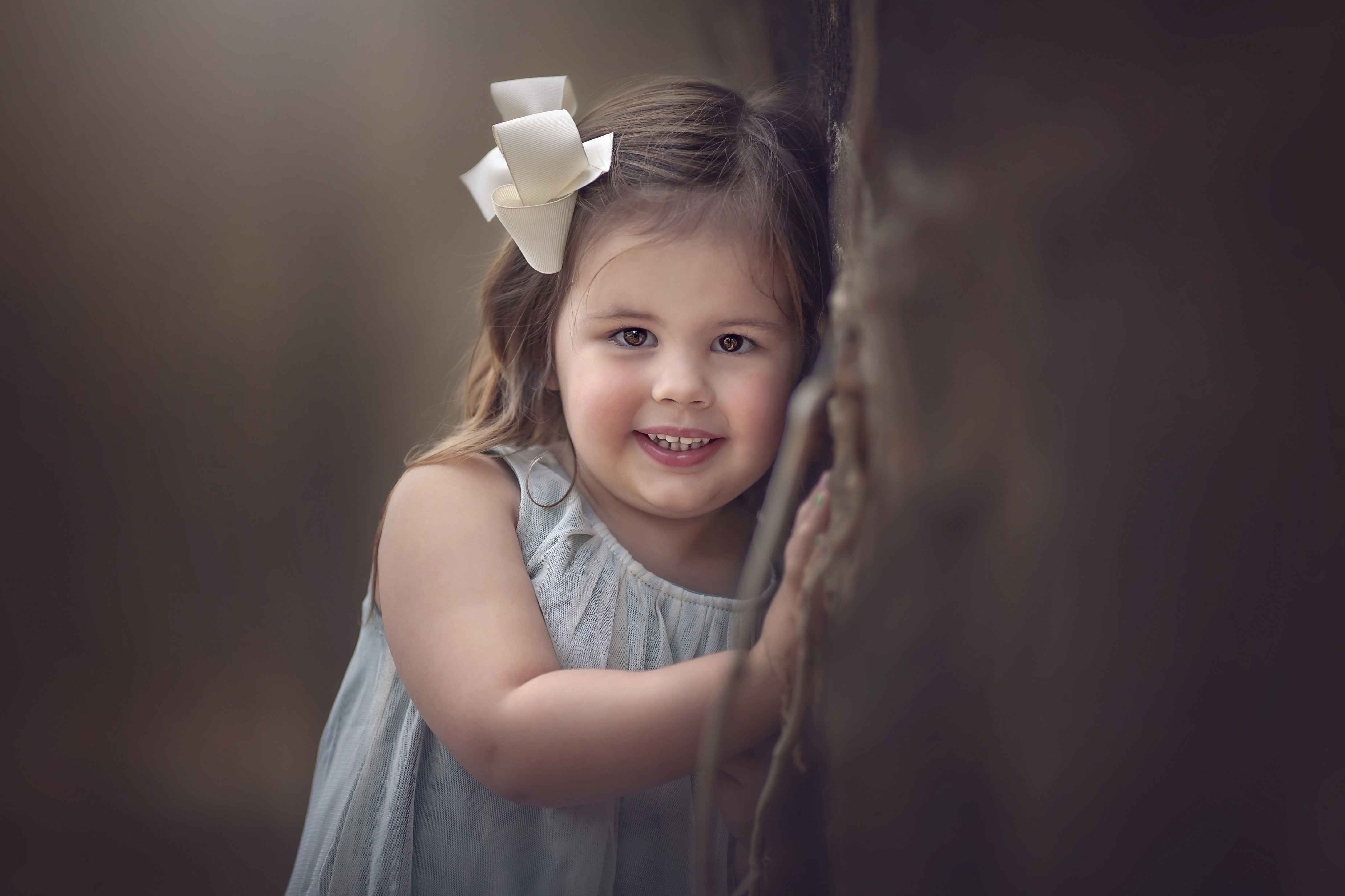 Little girl with a bow smiling HD Wallpaper