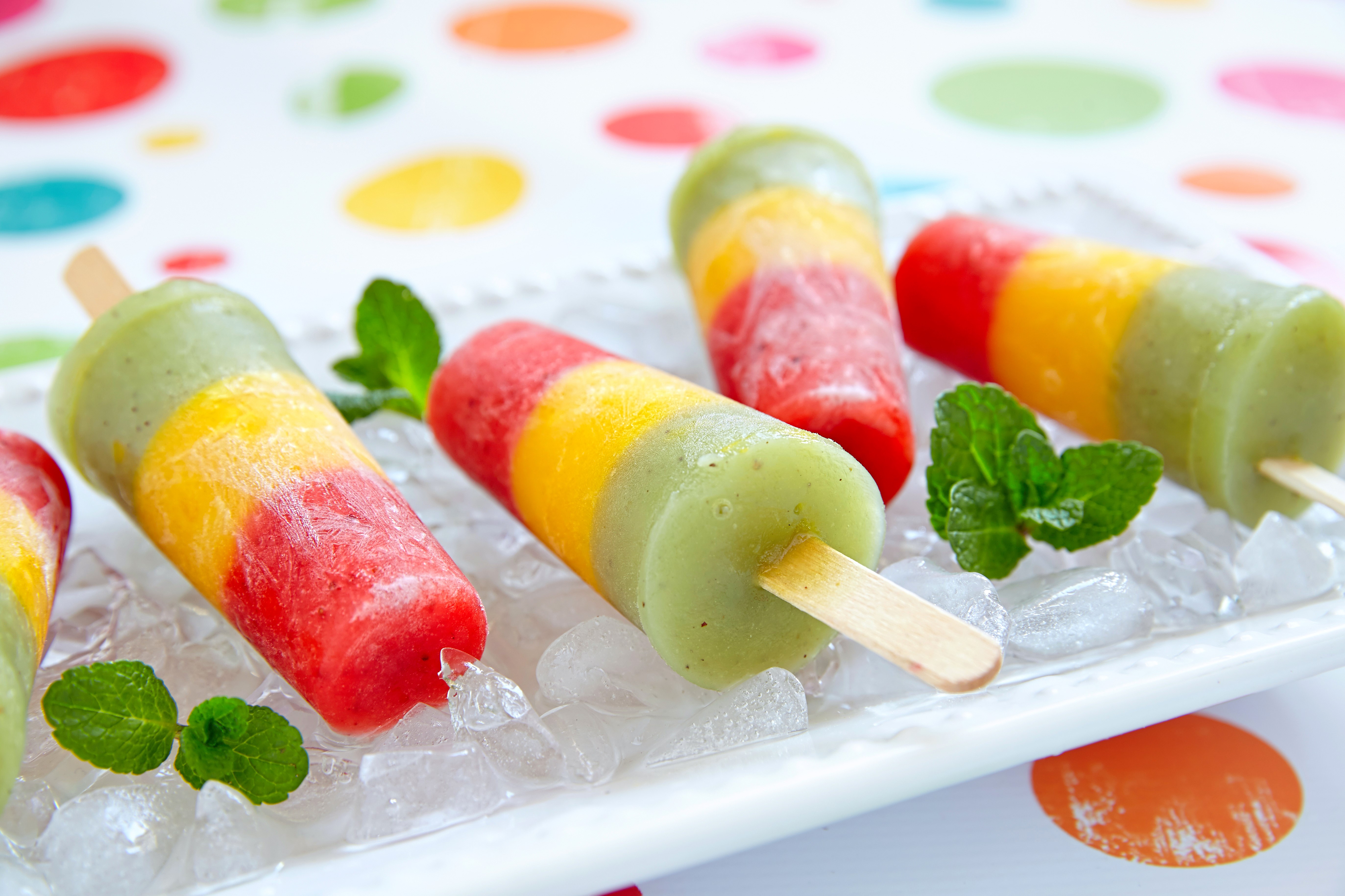 Tri-color popsicles on ice with mint leaves HD Wallpaper
