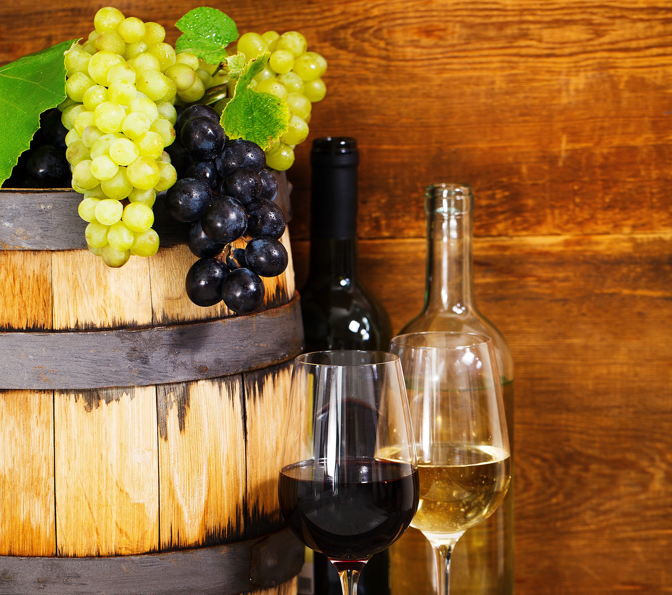 Wine barrel with grapes, bottles, and glasses HD Wallpaper