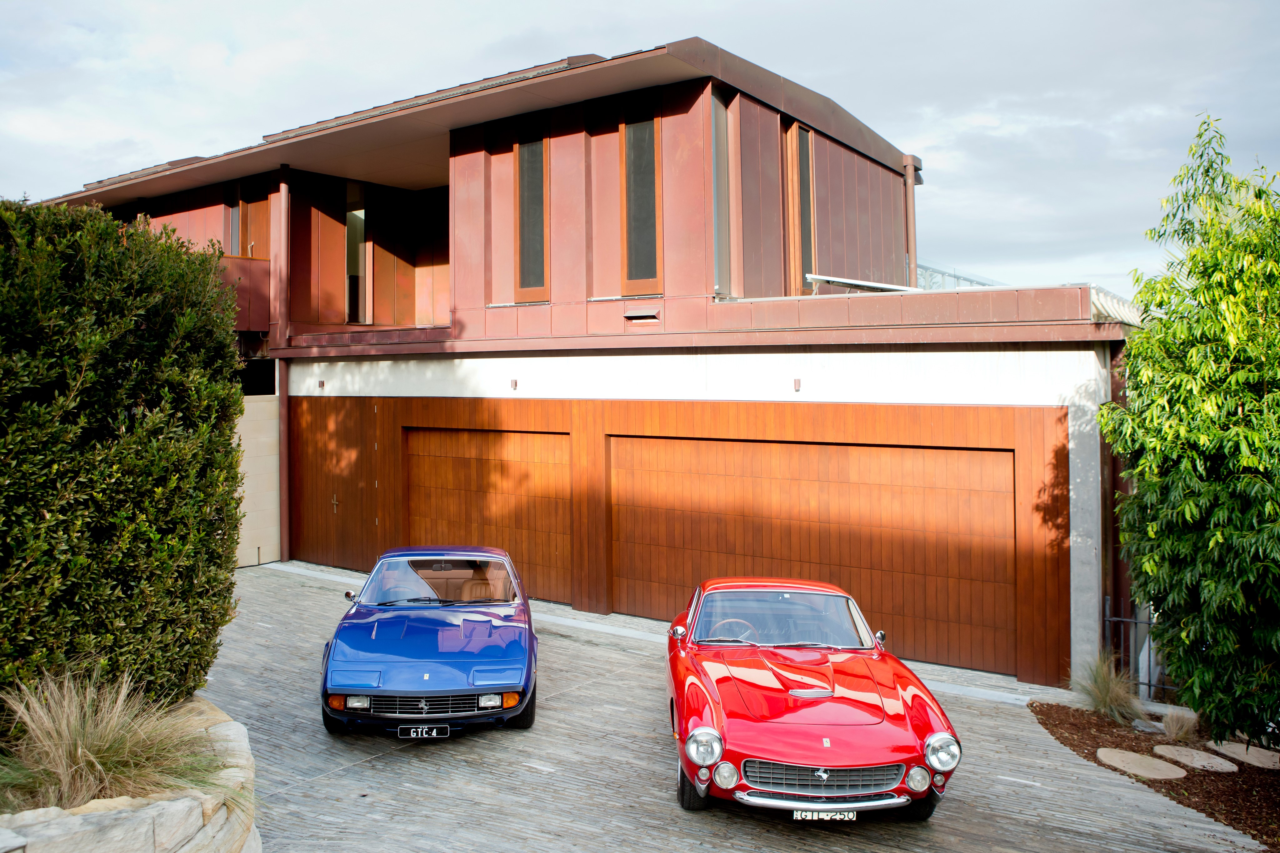 Two Ferrari cars in front of a modern house HD Wallpaper