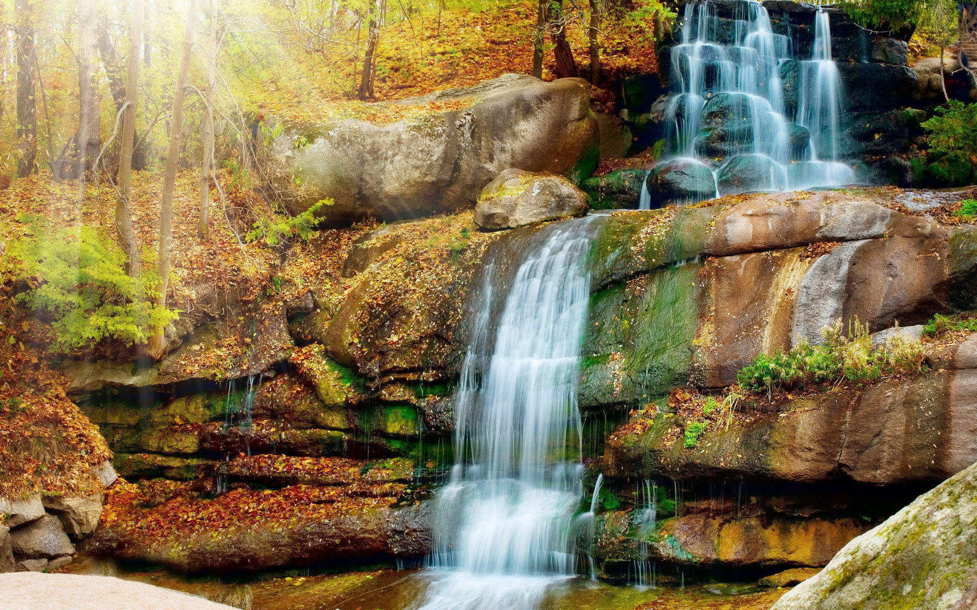 Waterfall in an autumn forest with sun rays HD Wallpaper