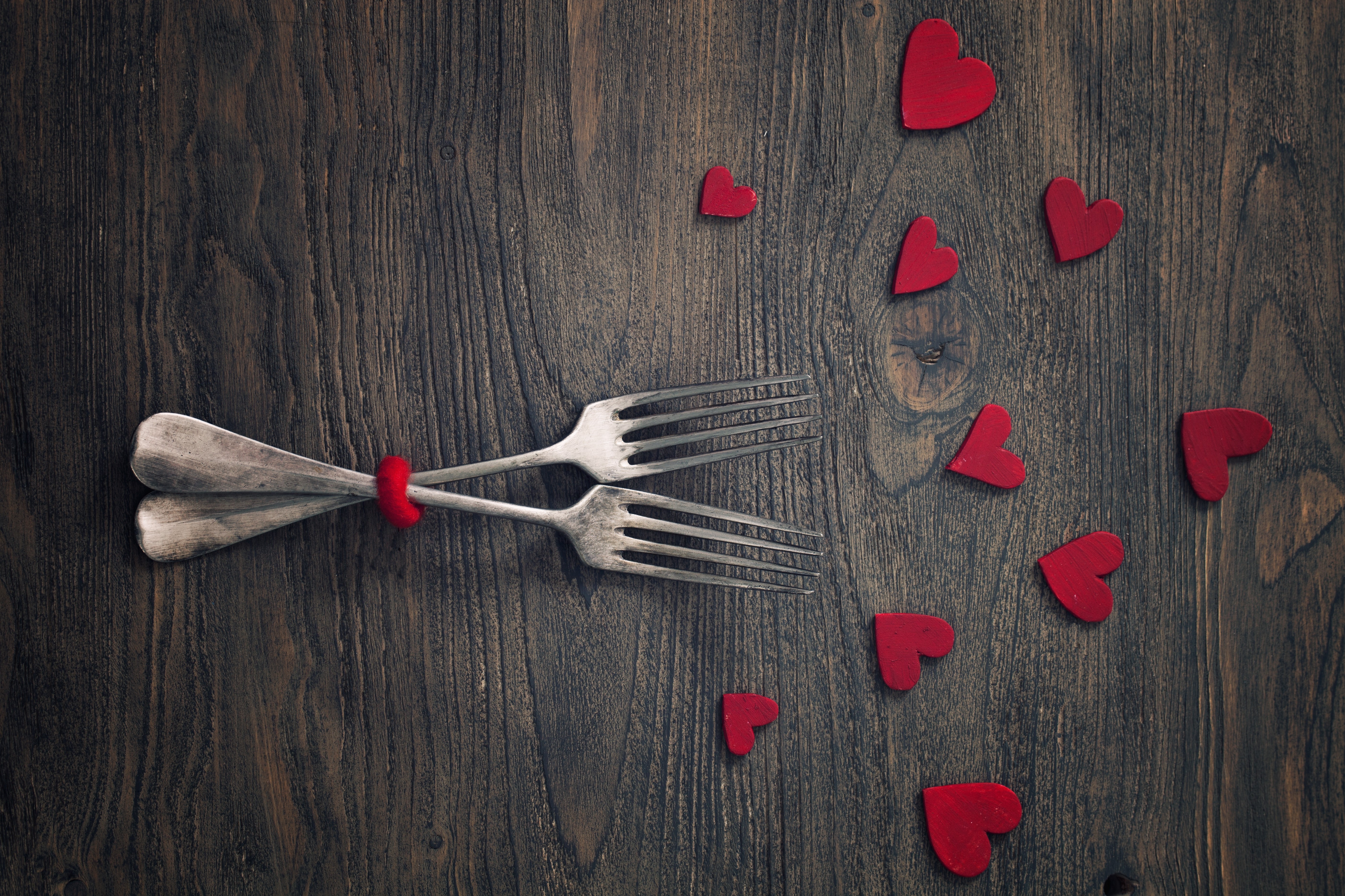 Two forks tied with red heart on wooden background HD Wallpaper