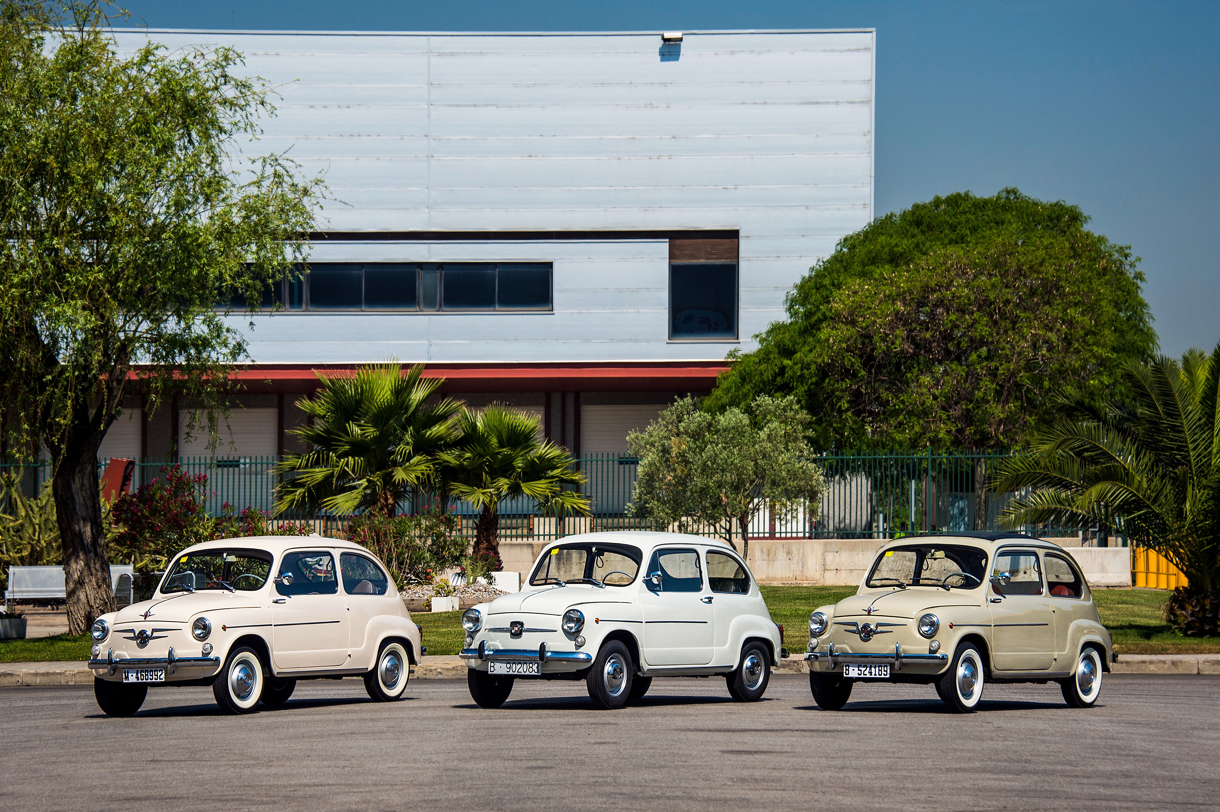 Three vintage Seat 600 cars parked in front of a building HD Wallpaper