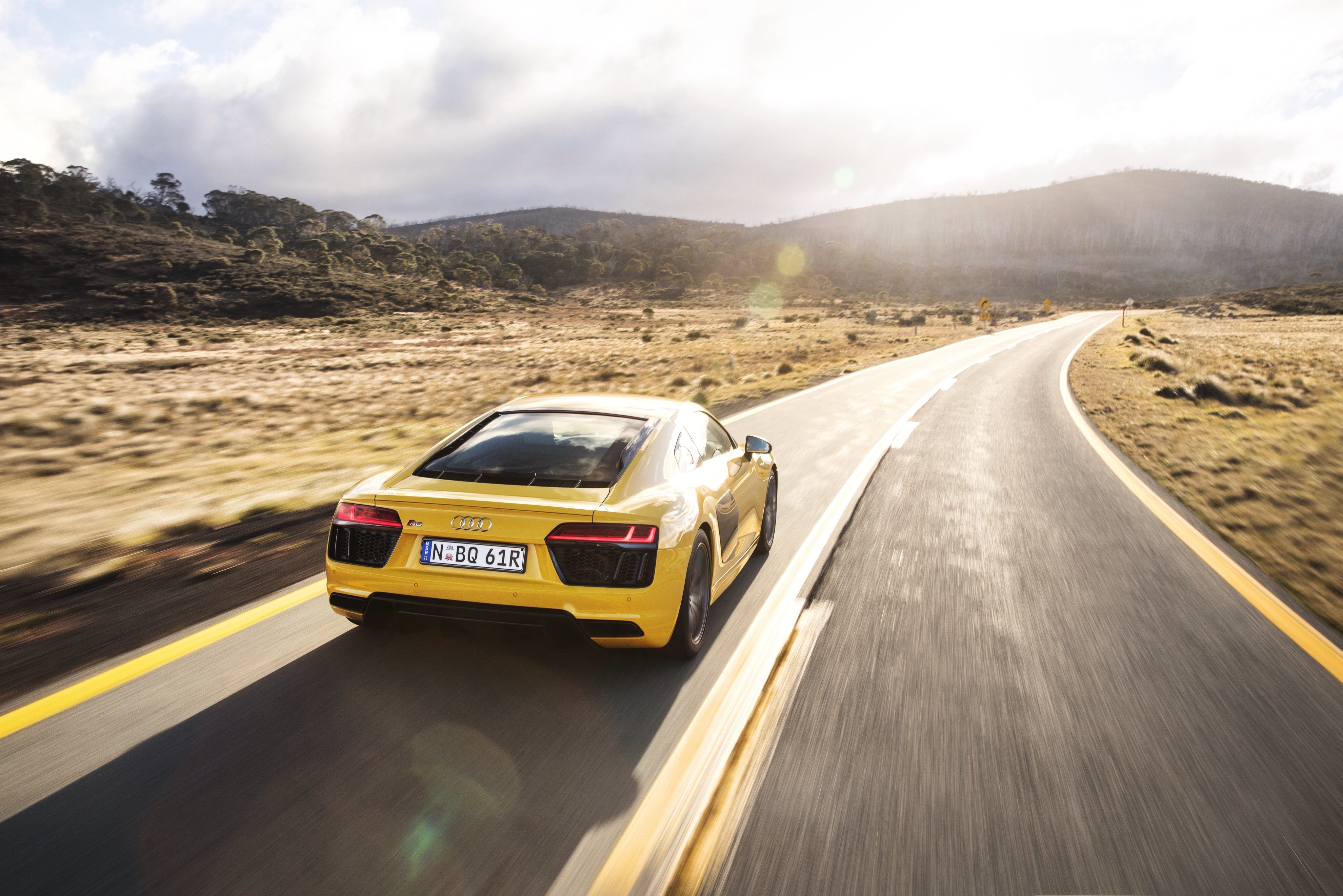 Yellow Audi R8 V10 driving on a road HD Wallpaper