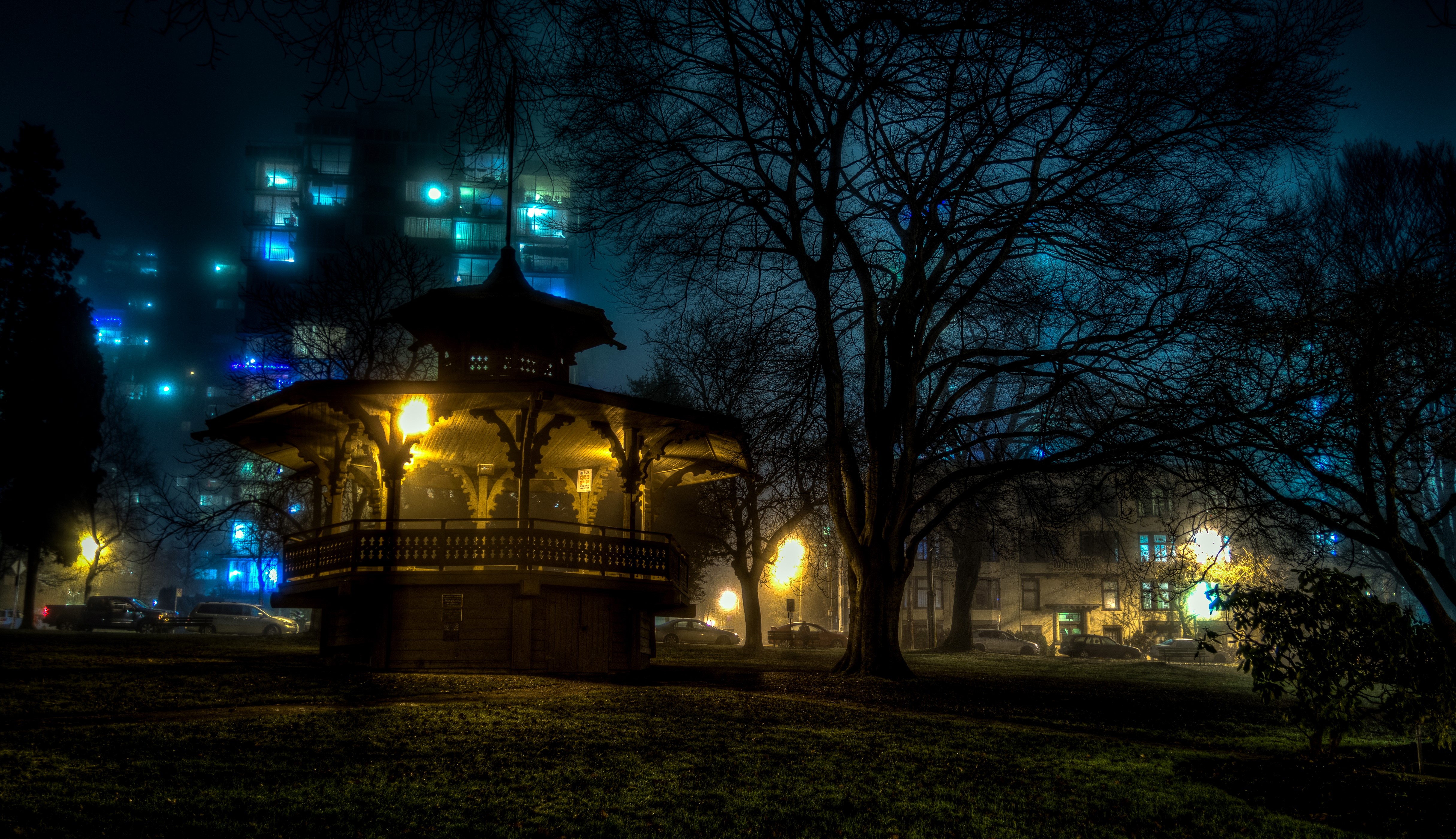 Pagoda in a park at night with city buildings HD Wallpaper