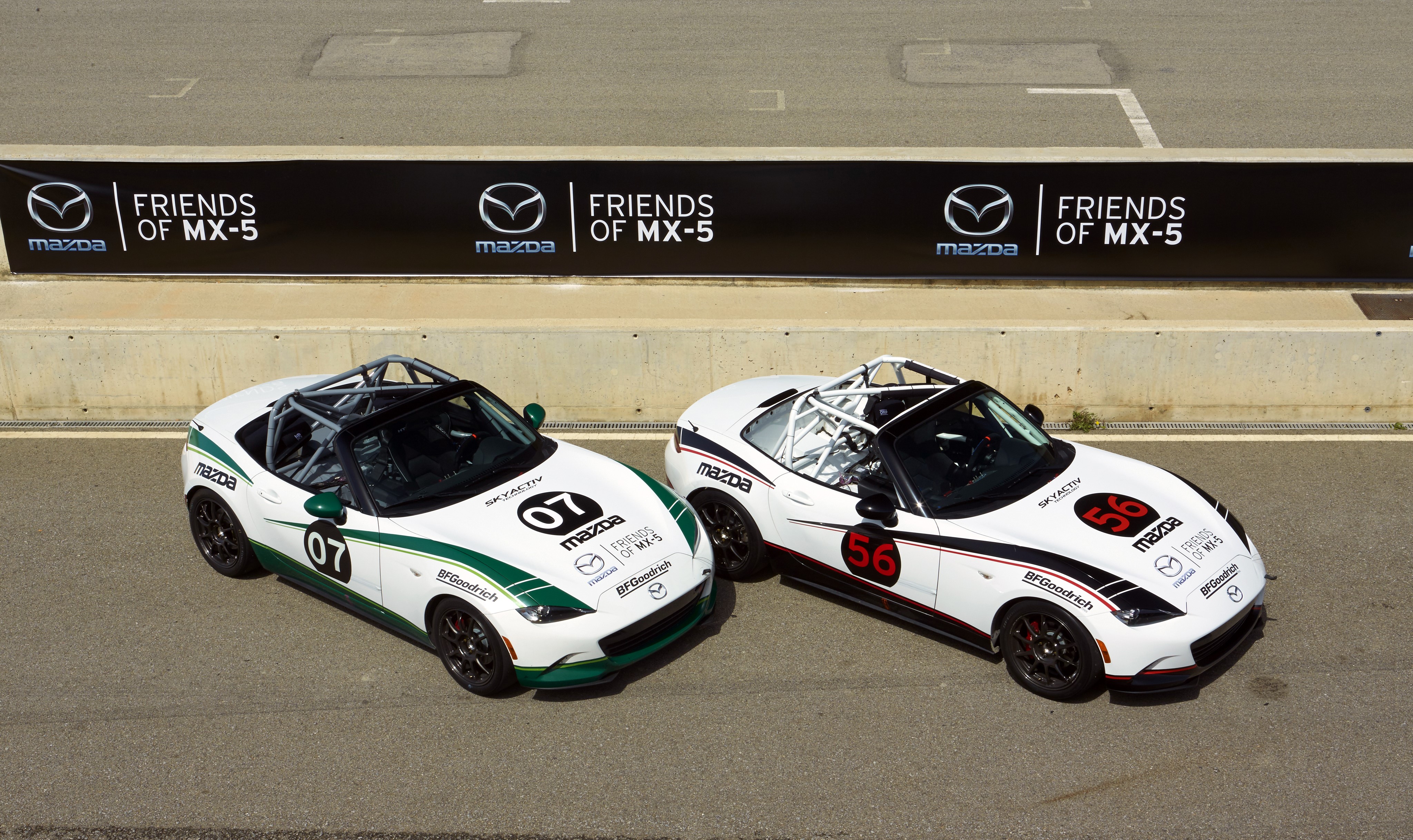 Two Mazda MX-5 Cup cars on a race track HD Wallpaper