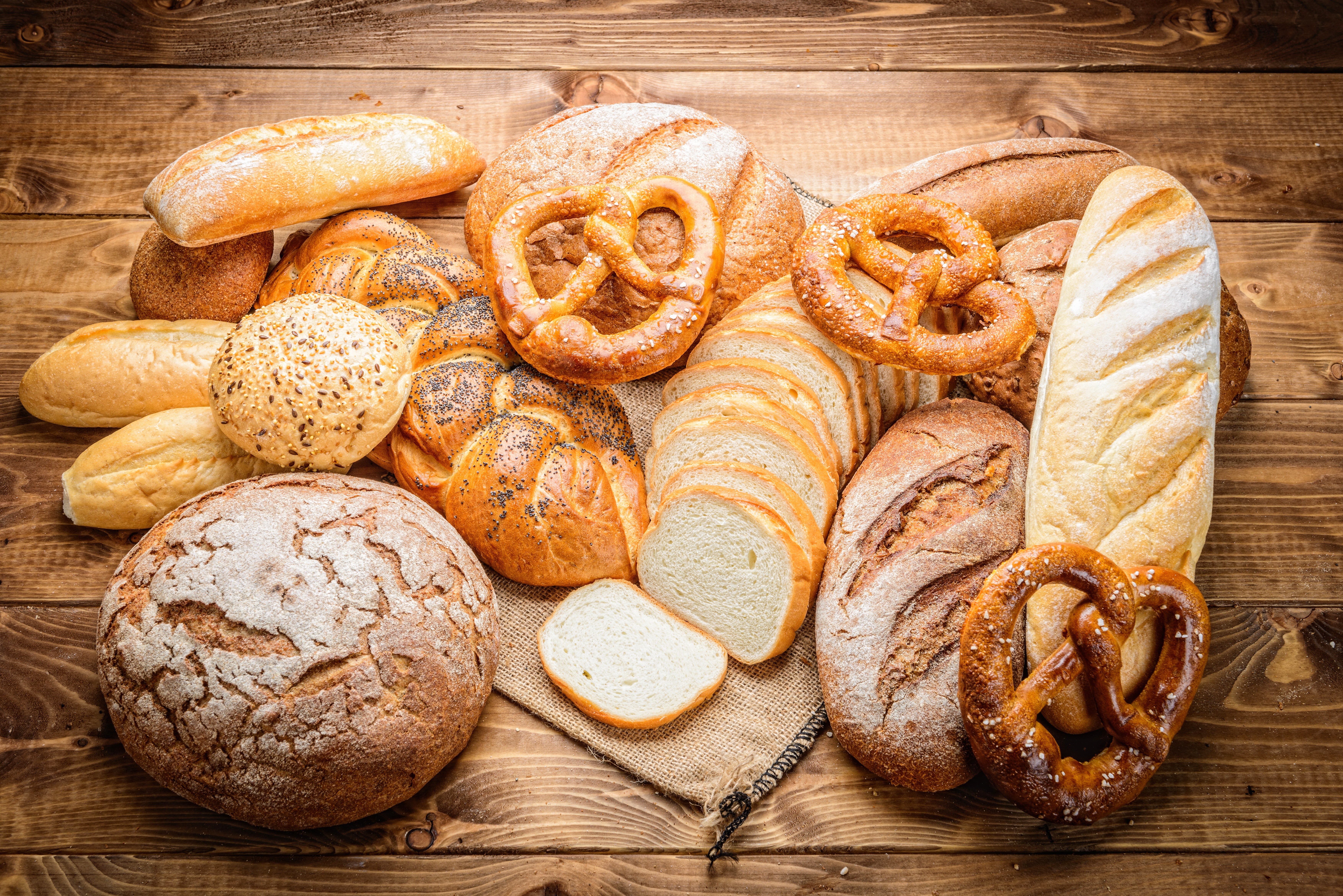 Assortment of Bread and Pretzels on Wooden Table HD Wallpaper