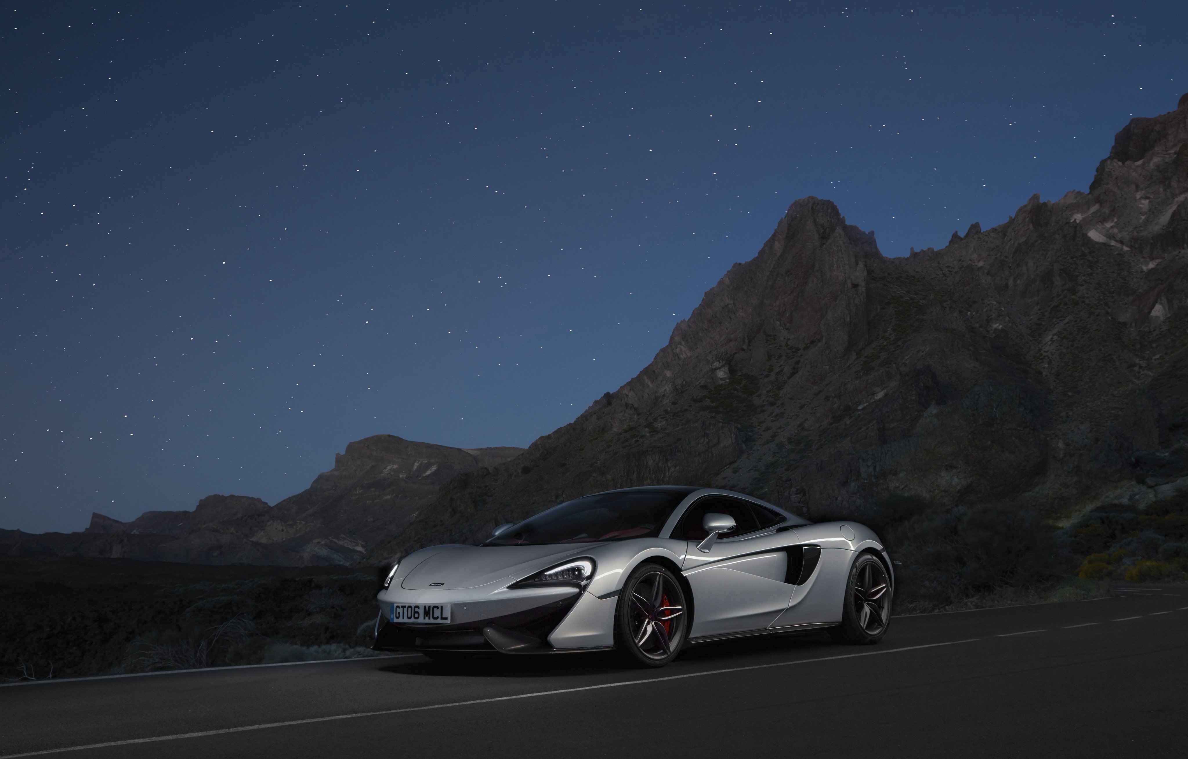 McLaren 570GT parked on a road at night HD Wallpaper