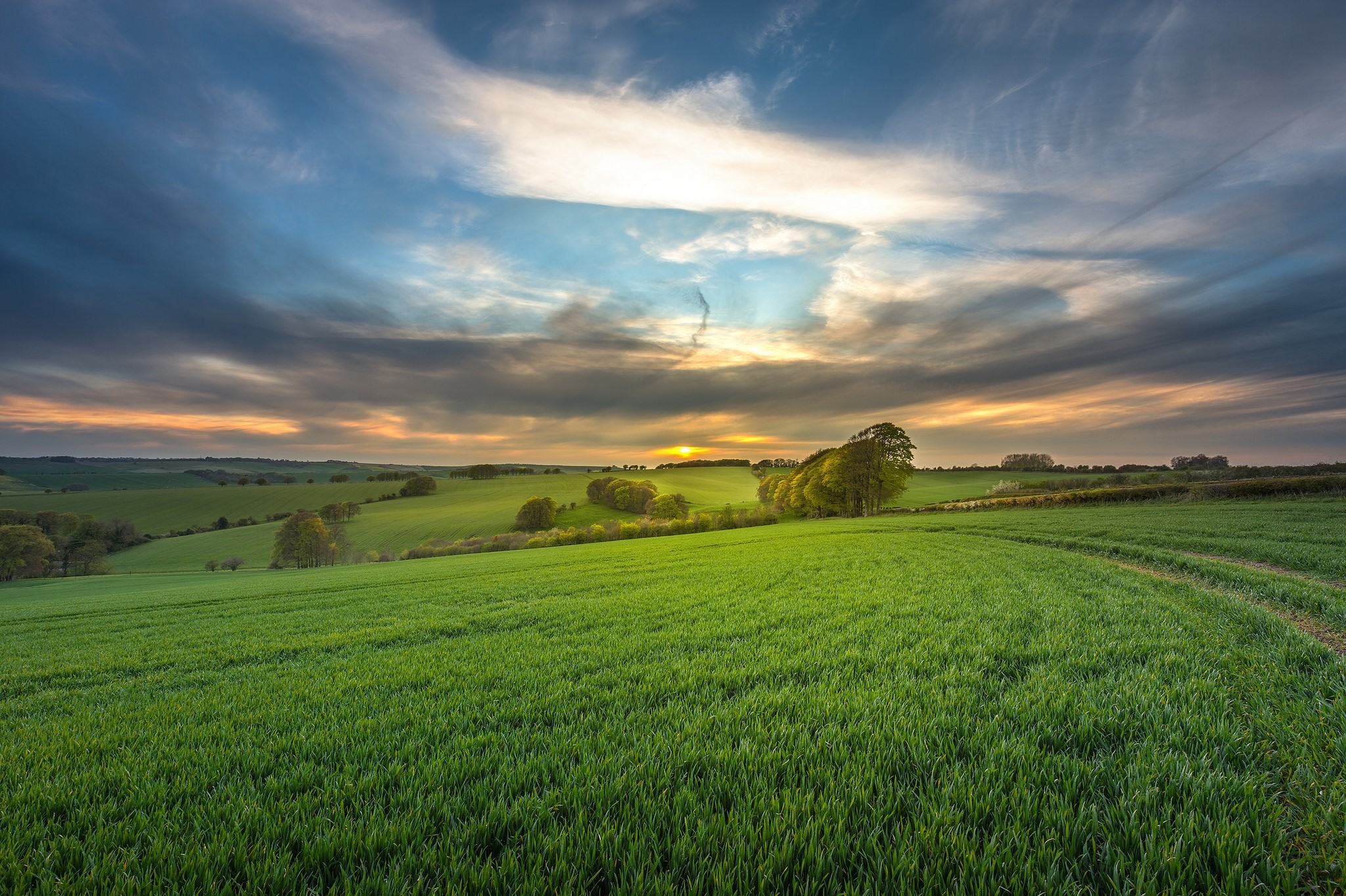 Rolling green fields under a dramatic sky in Wiltshire, England HD Wallpaper