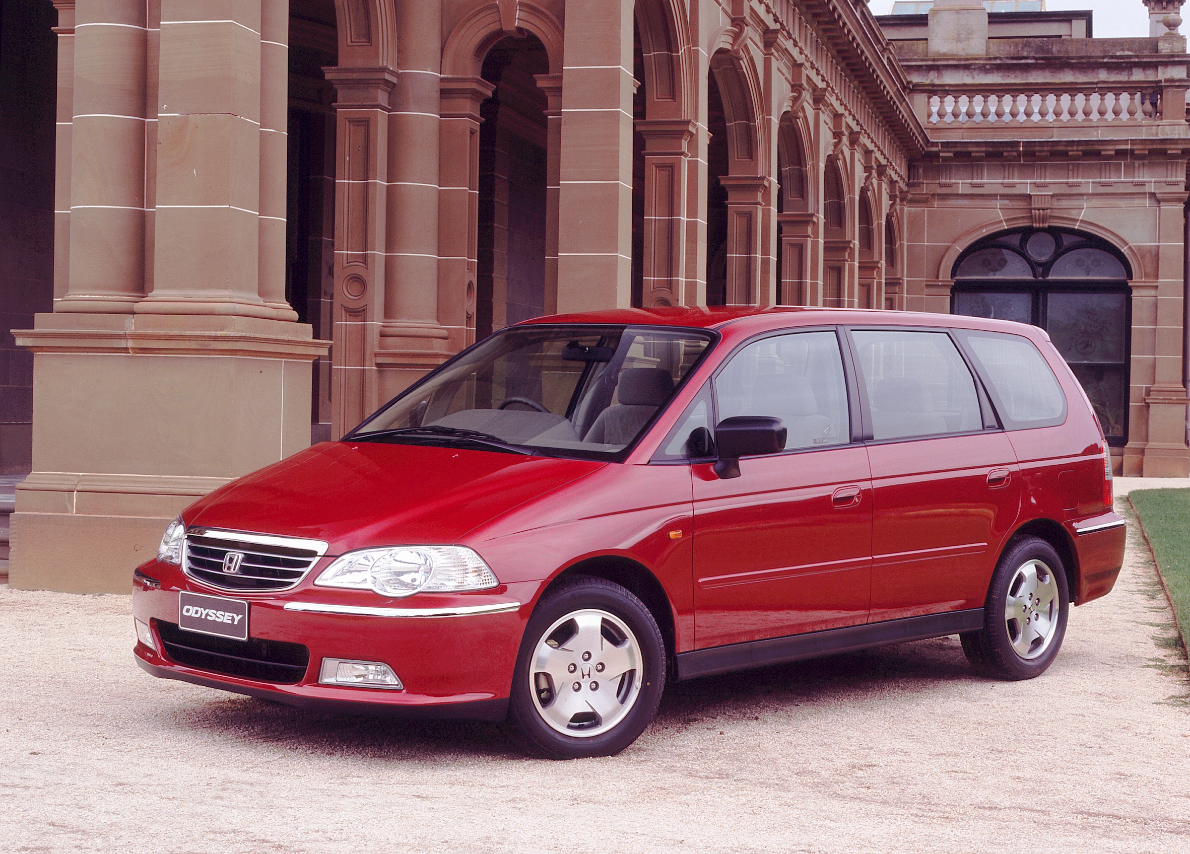 Red Honda Odyssey parked in front of a building HD Wallpaper