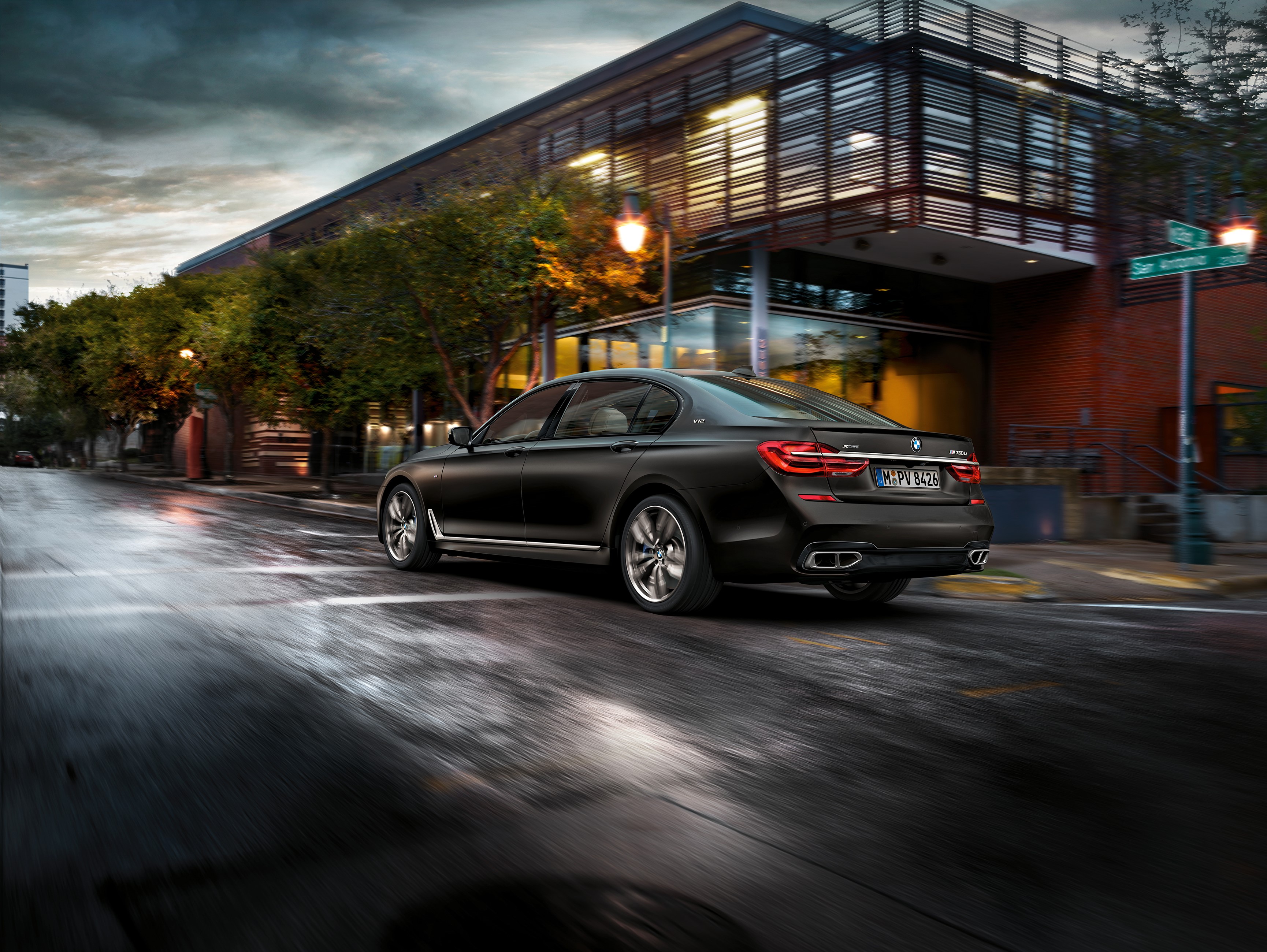 BMW M760Li xDrive driving on a wet city street HD Wallpaper