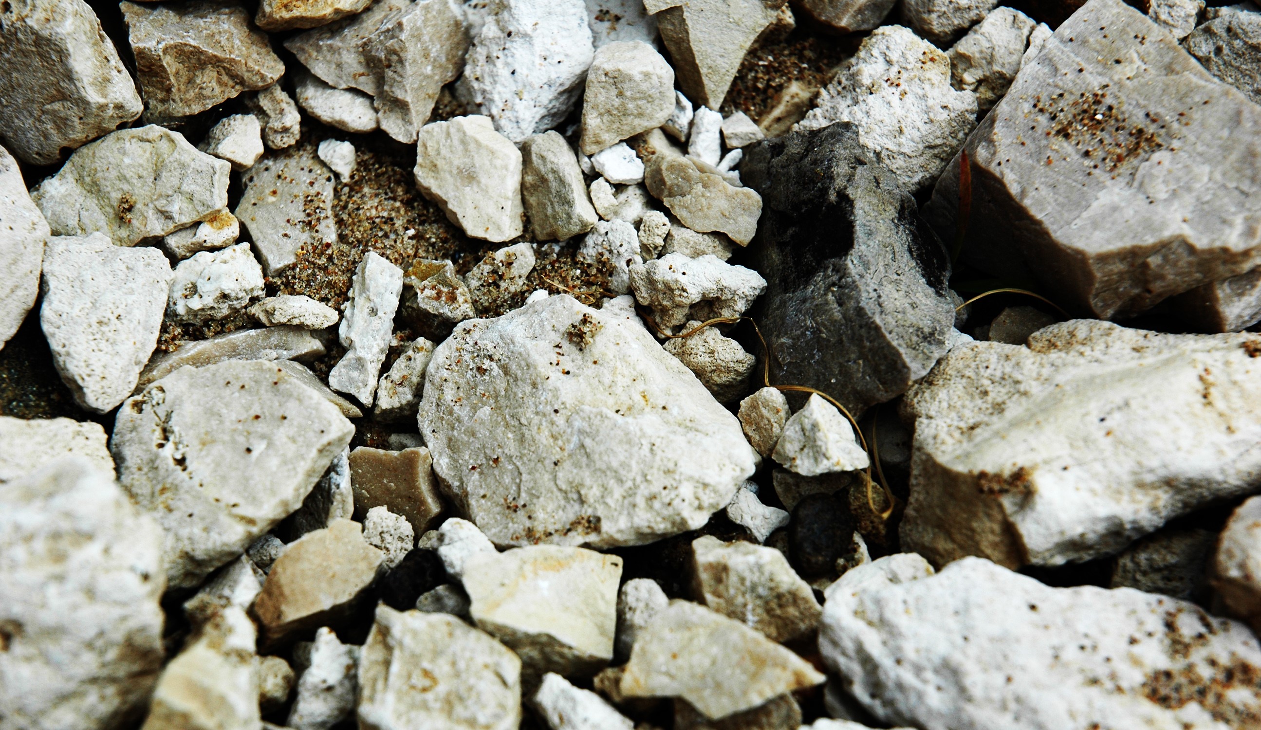 Close-up of rough, light-colored stones and sand HD Wallpaper
