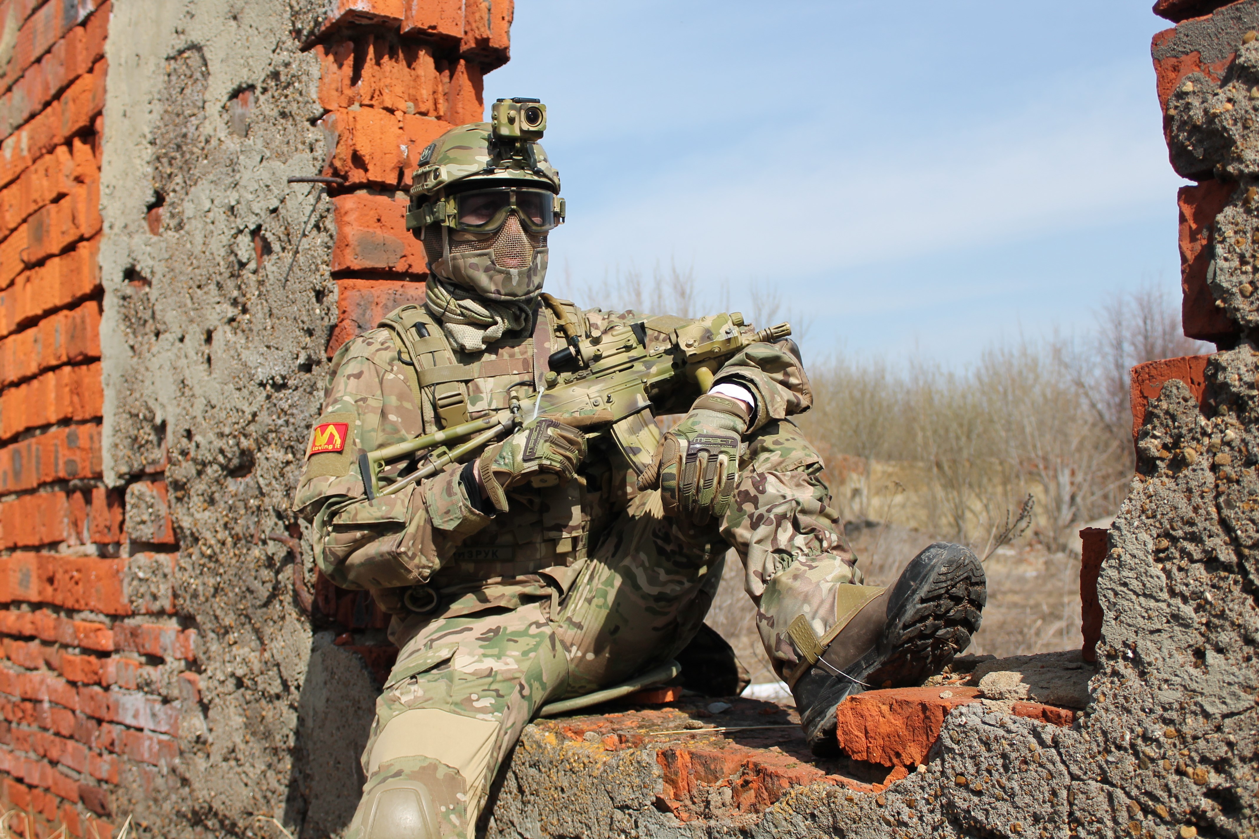 Soldier in camouflage sitting with a rifle HD Wallpaper