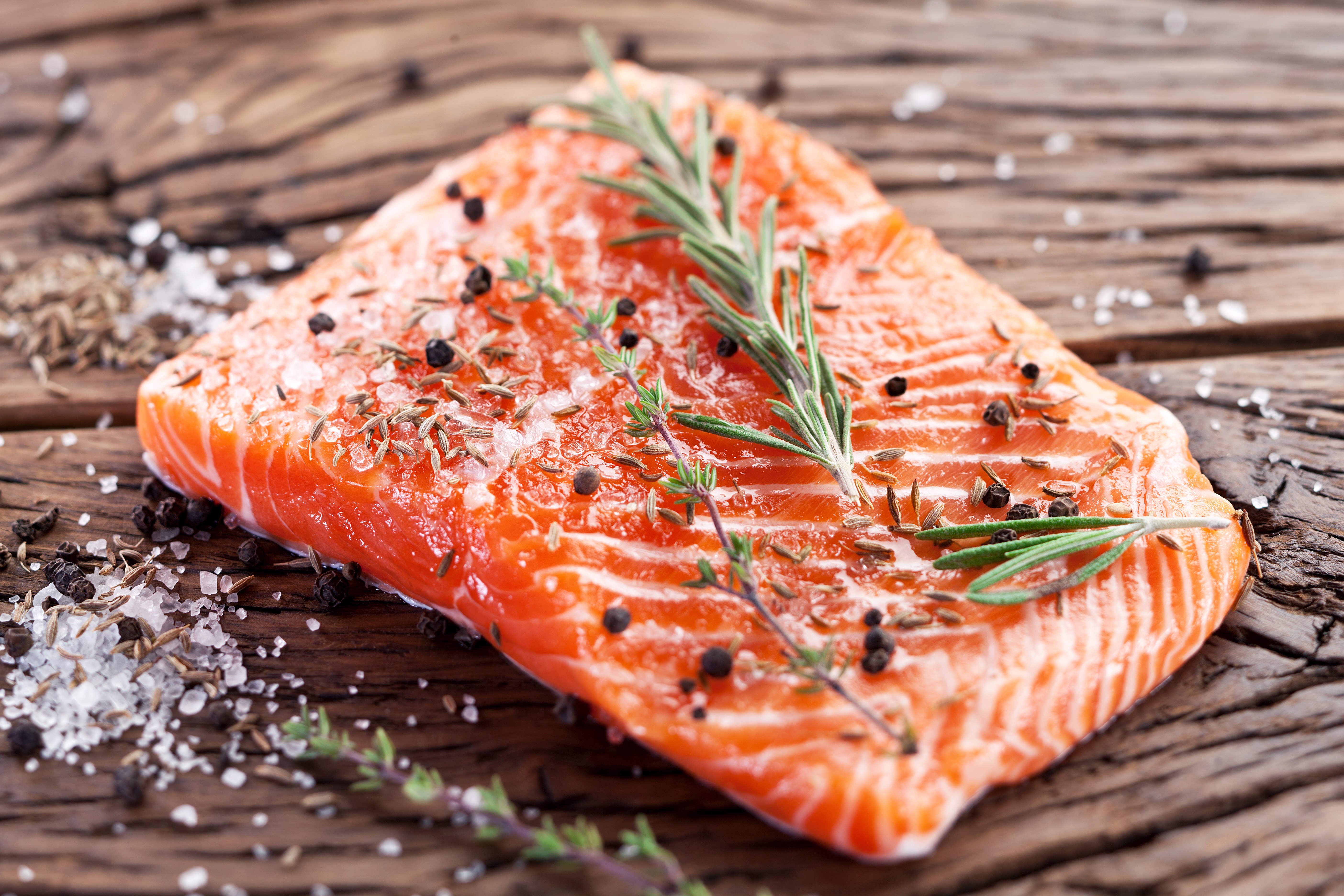 Salmon fillet seasoned with spices on wooden board HD Wallpaper